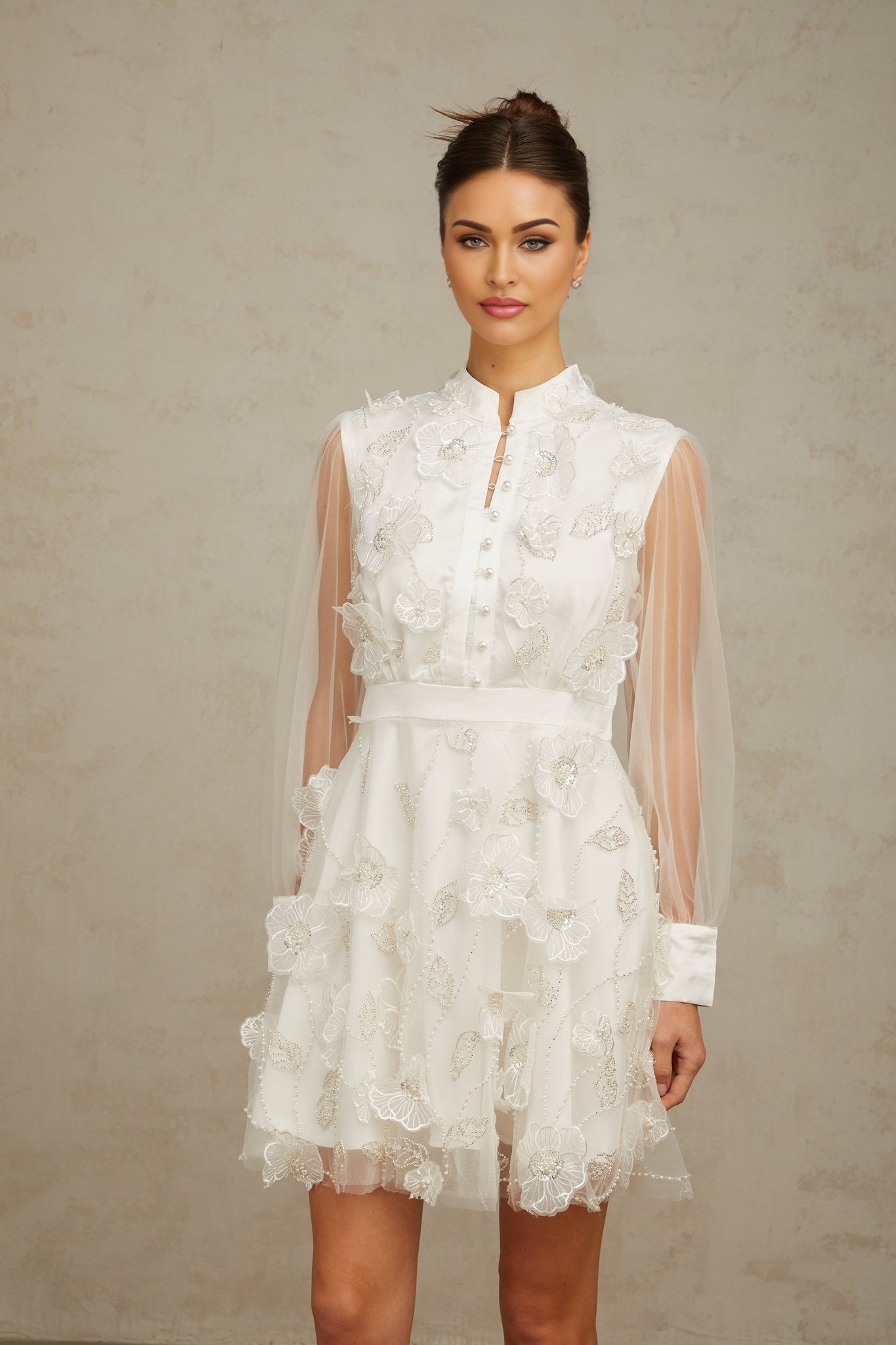 A short white mini dress with 3D floral petal details made of tulle fabric named Camille