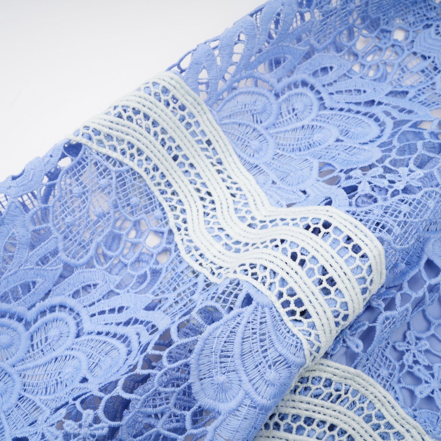 A short white mini dress with a Vneck and colorful floral embroidery across the bodice and sleeves