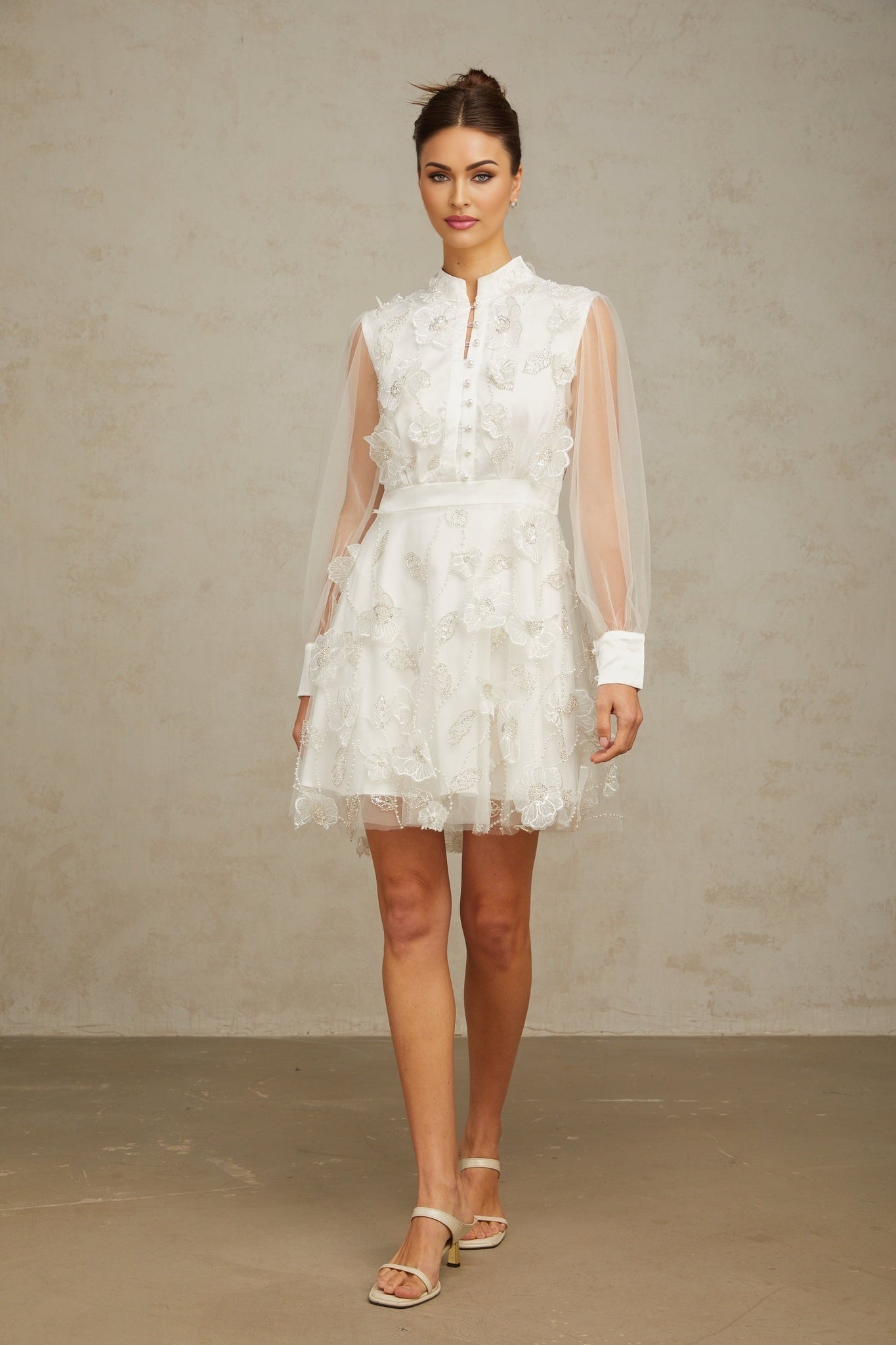 A short white mini dress with delicate 3D floral petal details made of tulle fabric named Camille