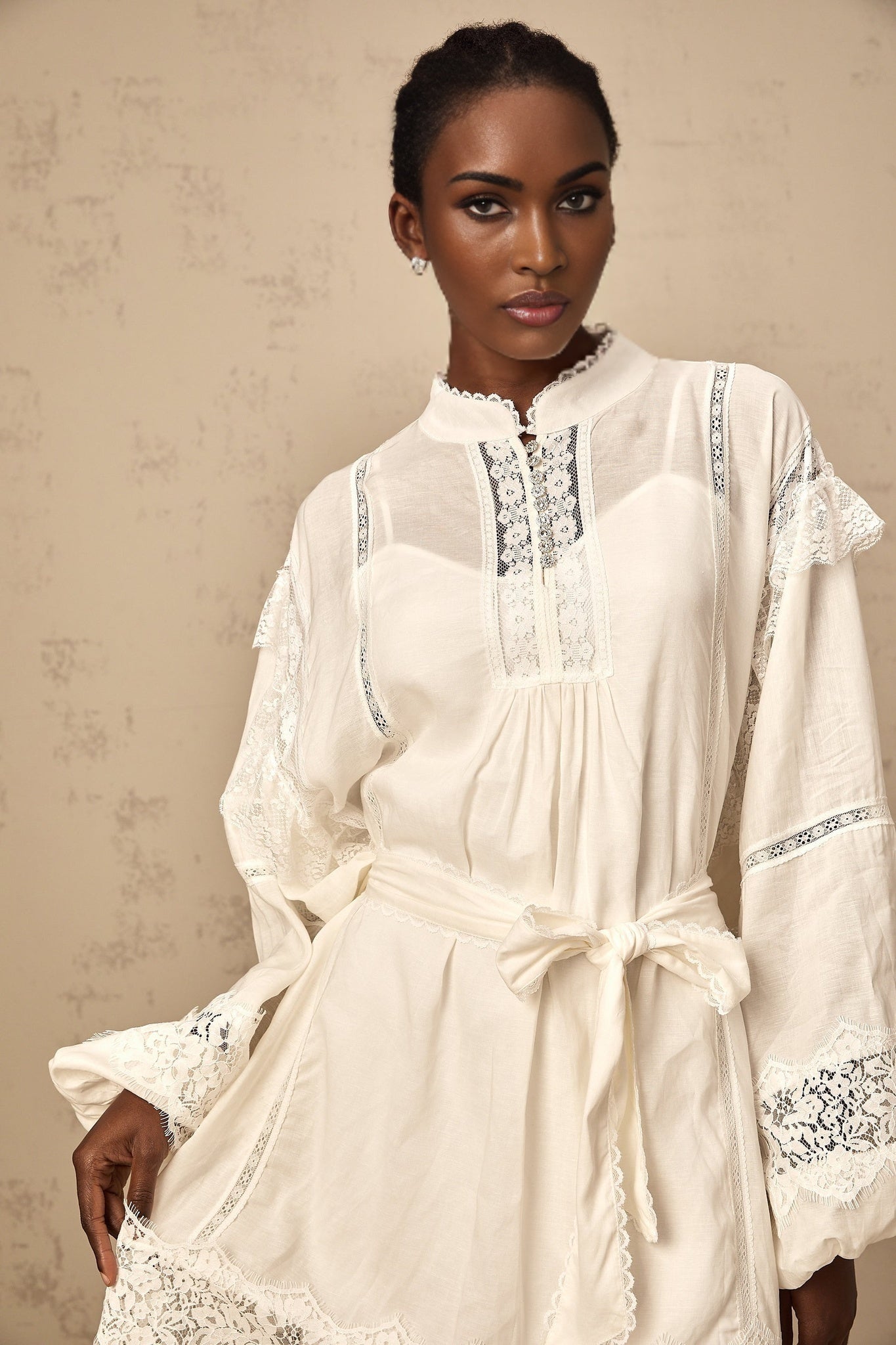 A short white mini dress with floral lace trim details