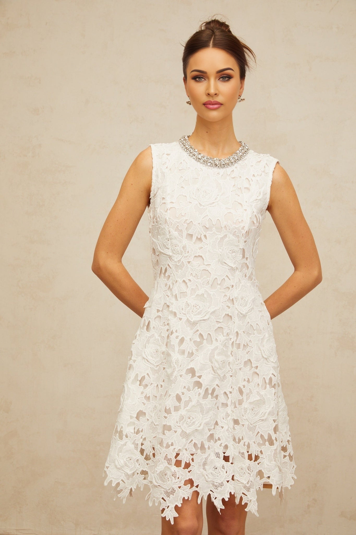 A short white mini dress with intricate embellished corded lace details featuring delicate patterns and textures