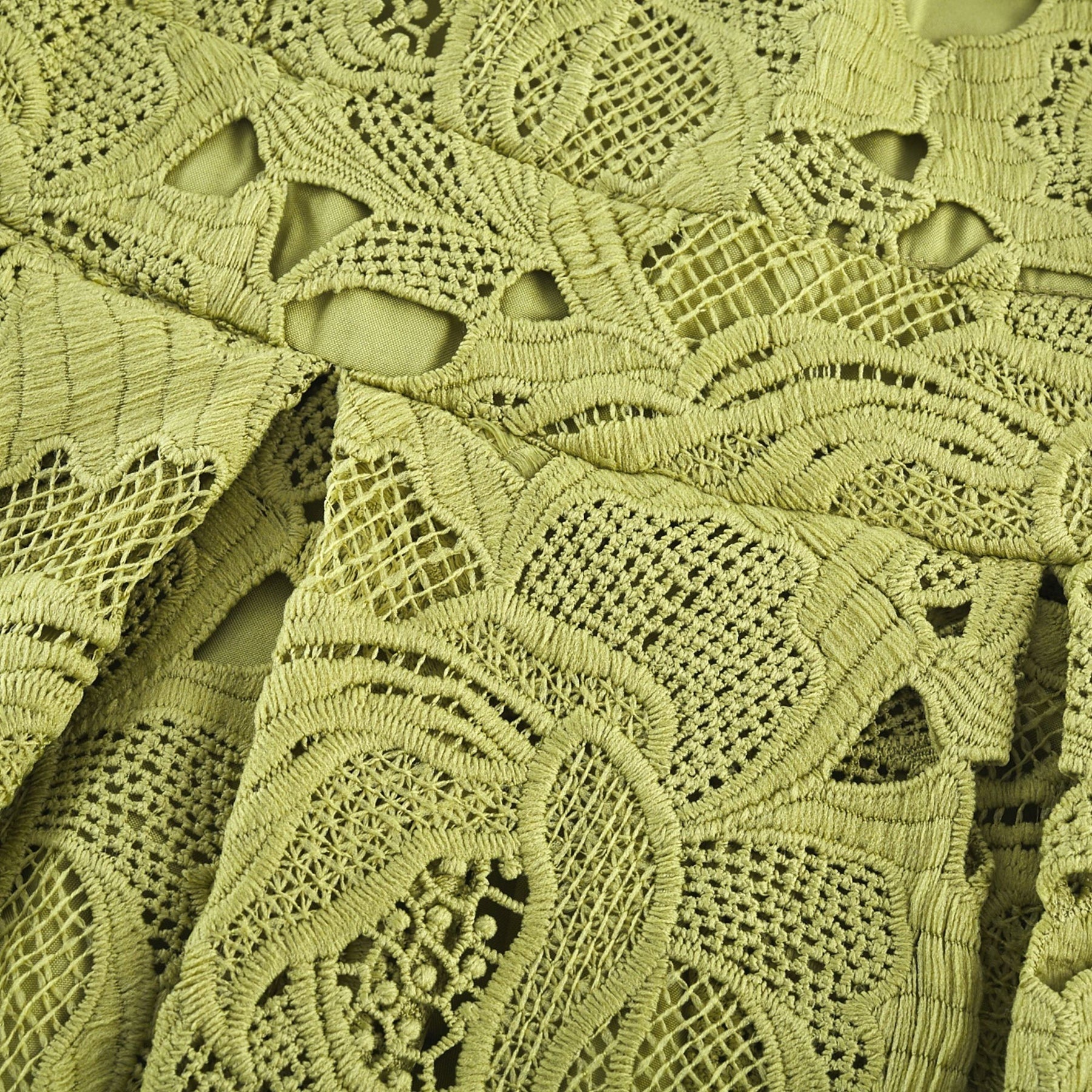 A short white minidress with embroidered details and cutout sections on a female model