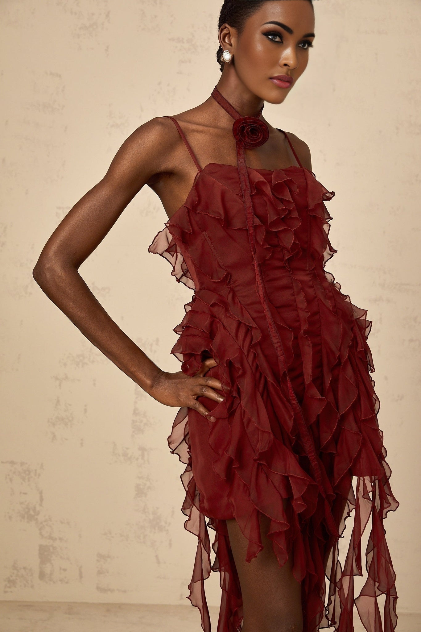 A short winered mini dress with ruffled details and rose appliques decorating the fabric