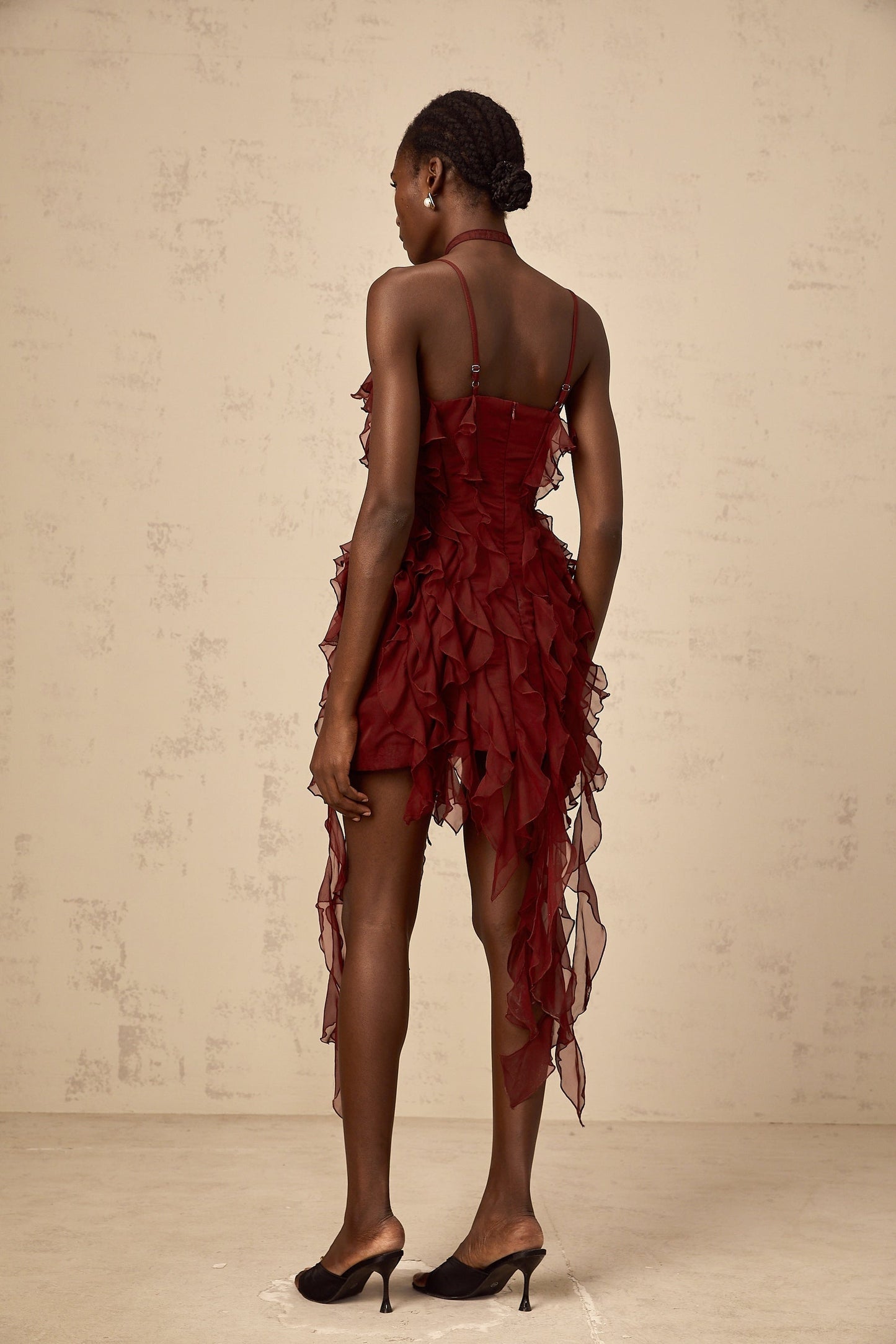 A short winered mini dress with ruffled details and rose appliques decorating the fabric