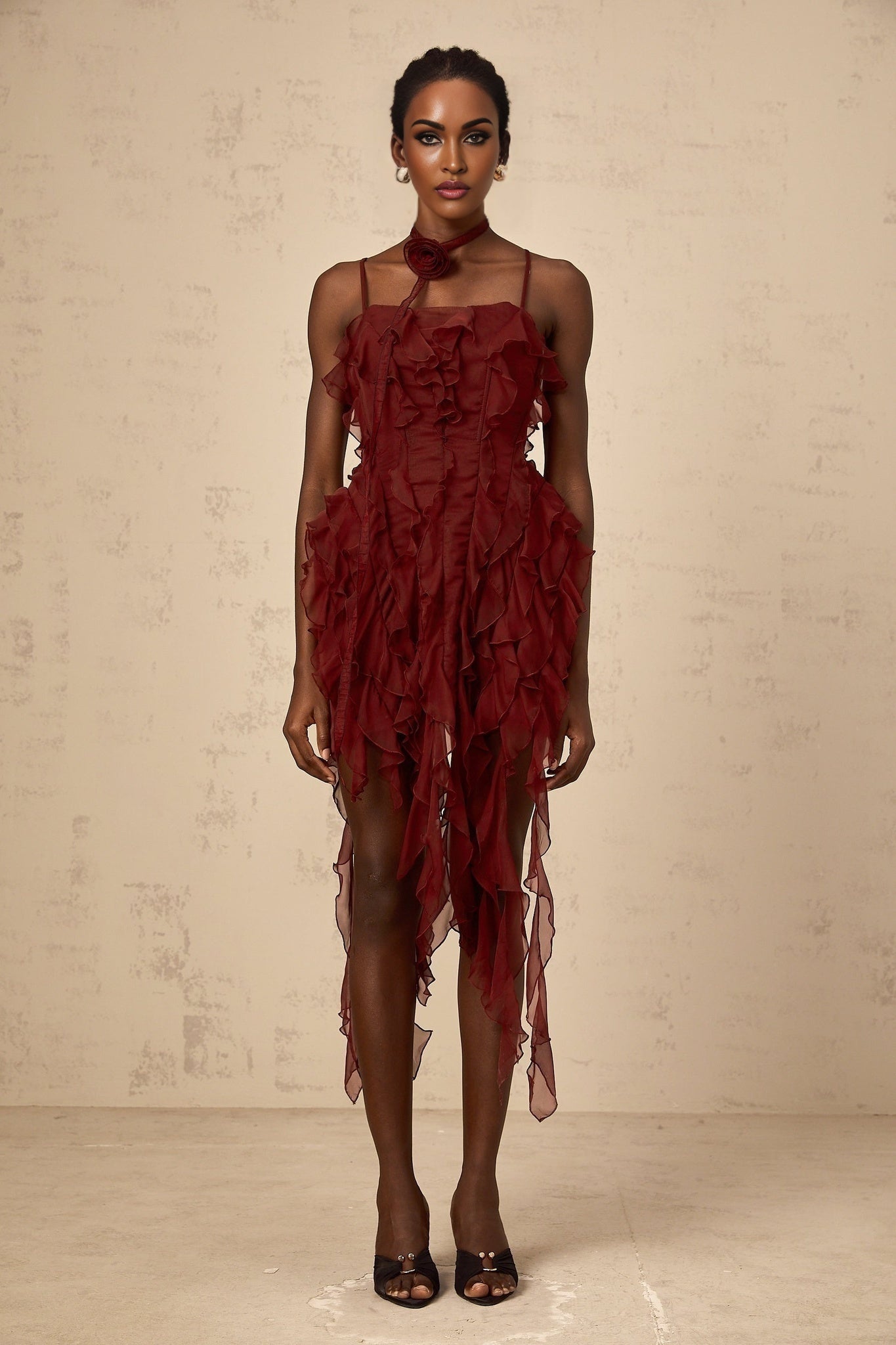 A short winered mini dress with ruffled details and rose appliques on the fabric