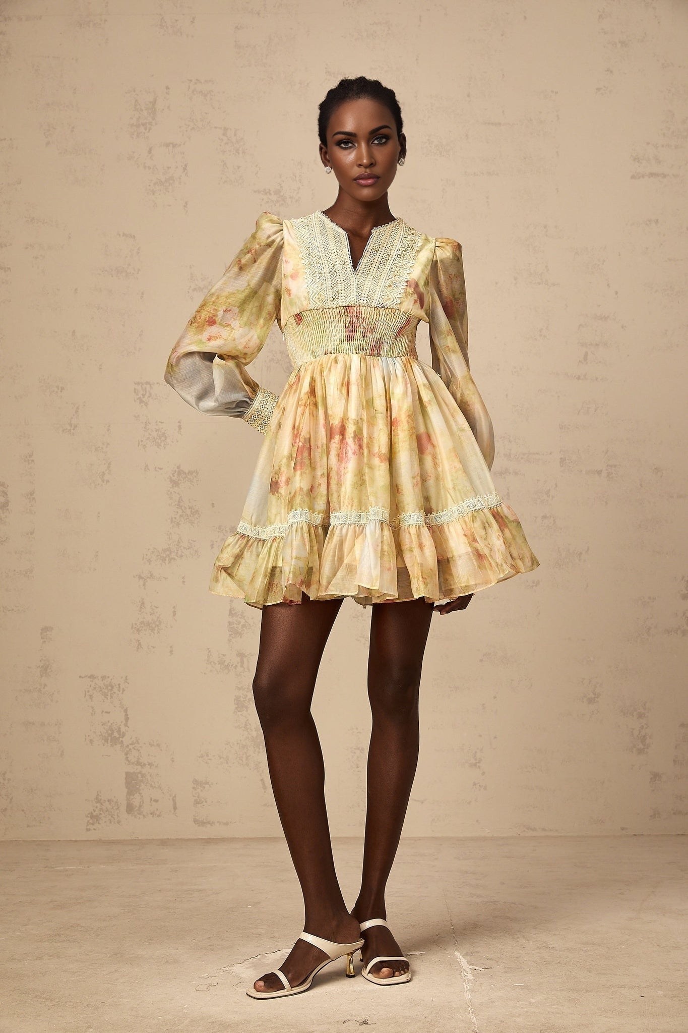 A short yellow dress with floral print and lace panelling details named Olivia
