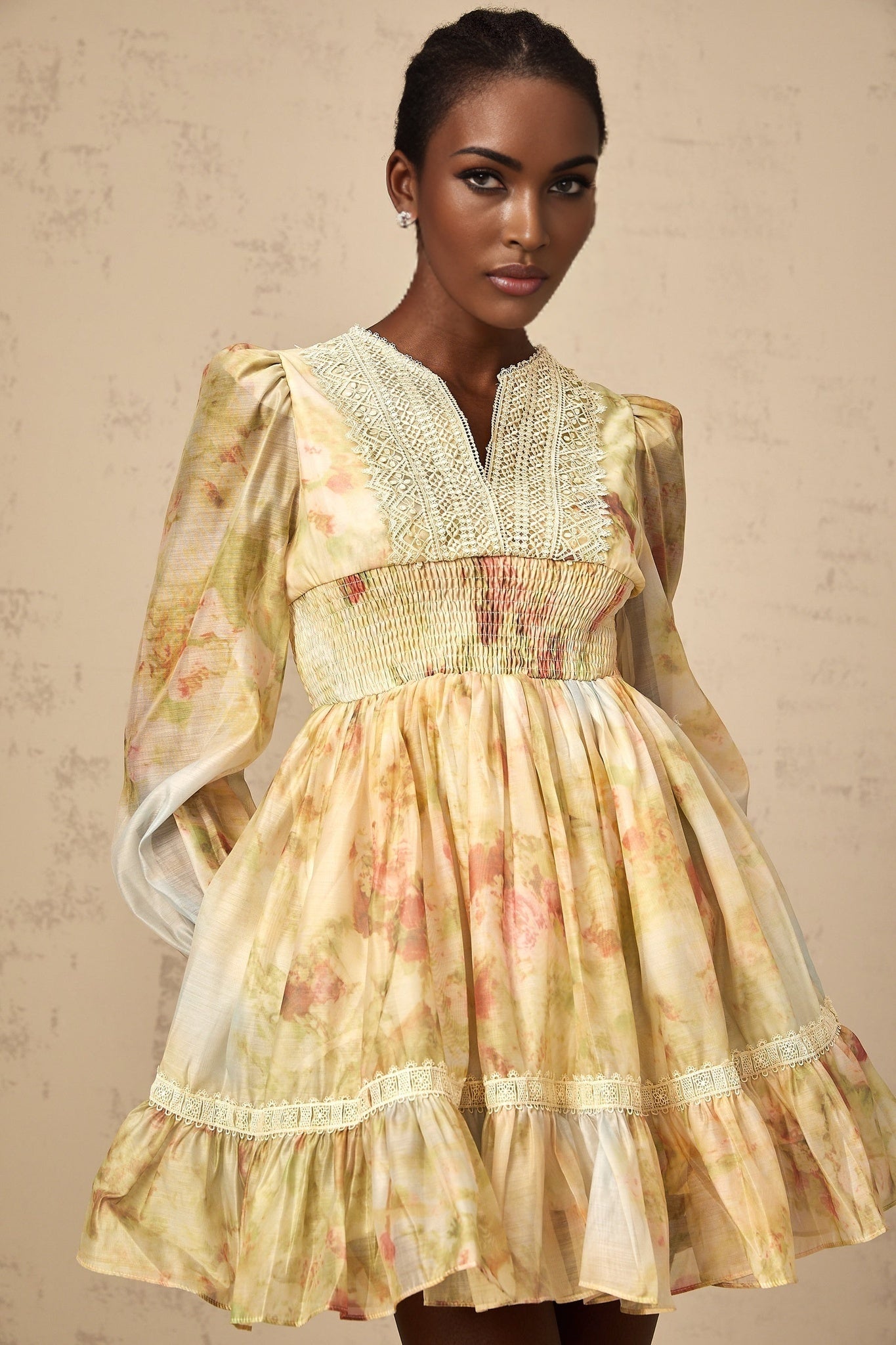 A short yellow dress with lace panels and a floral print pattern worn by a model named Olivia