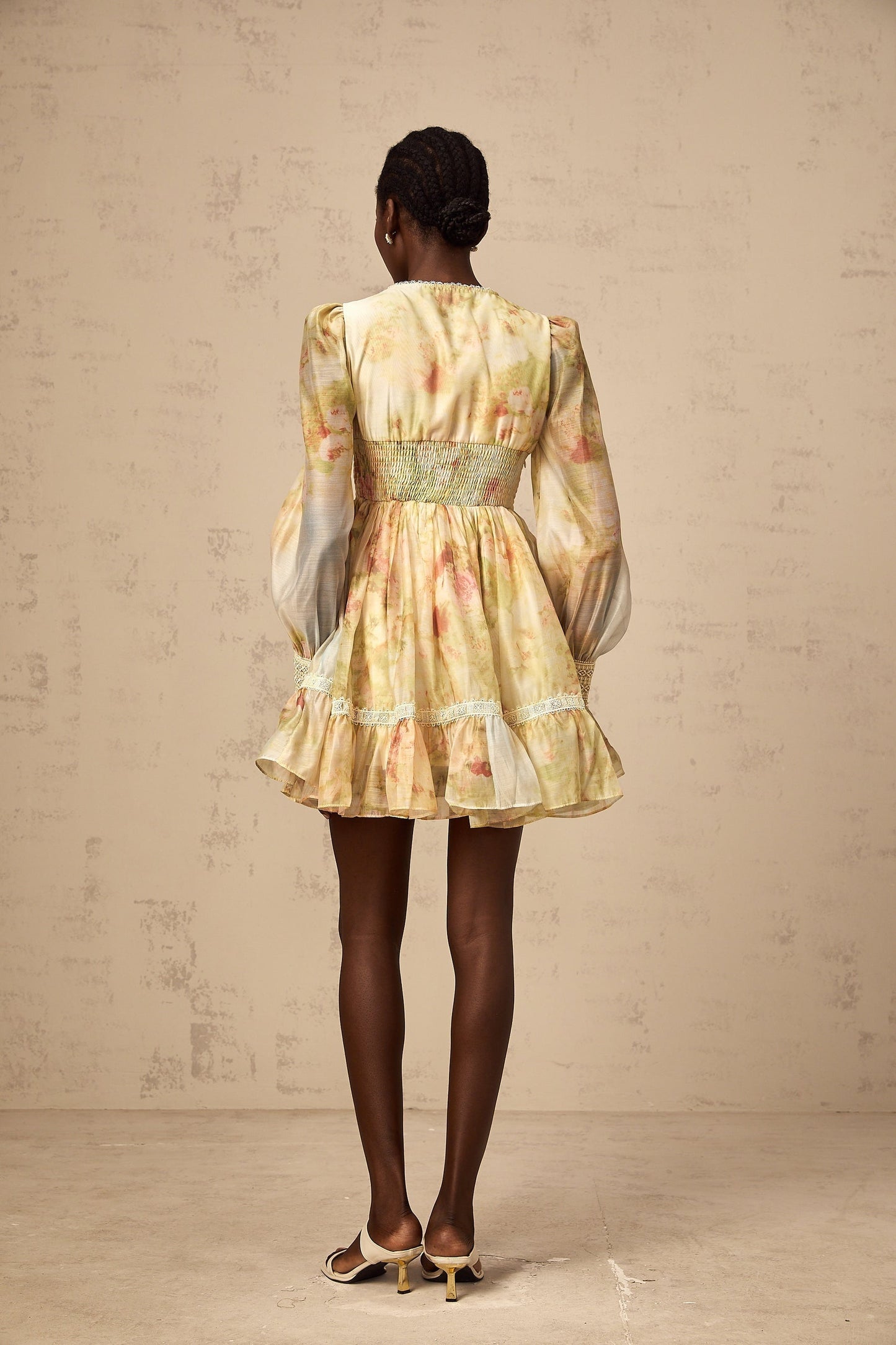 A short yellow dress with lace panels and floral print pattern in a mini length style called Olivia