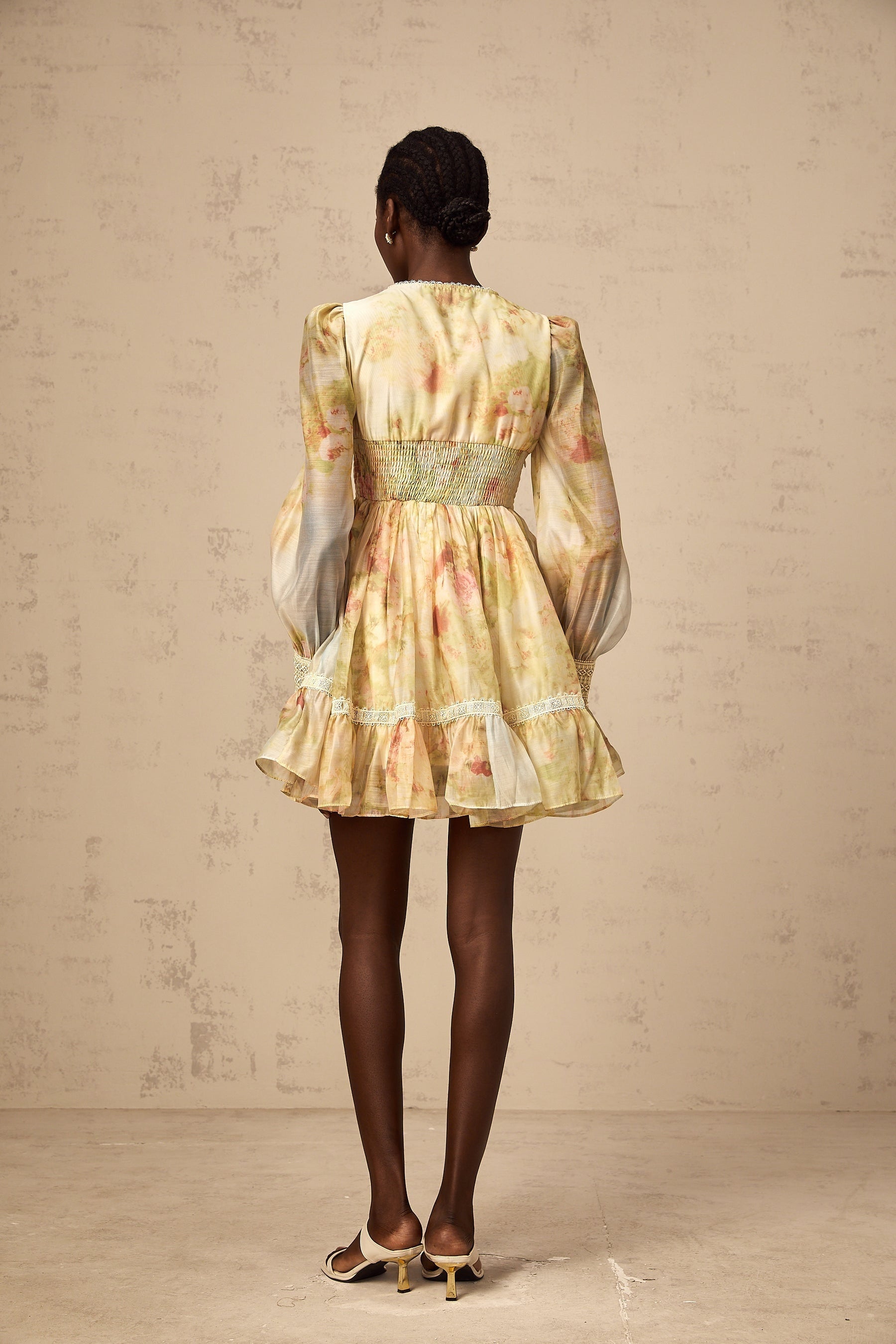 A short yellow dress with lace panels and floral print pattern in a mini length style called Olivia