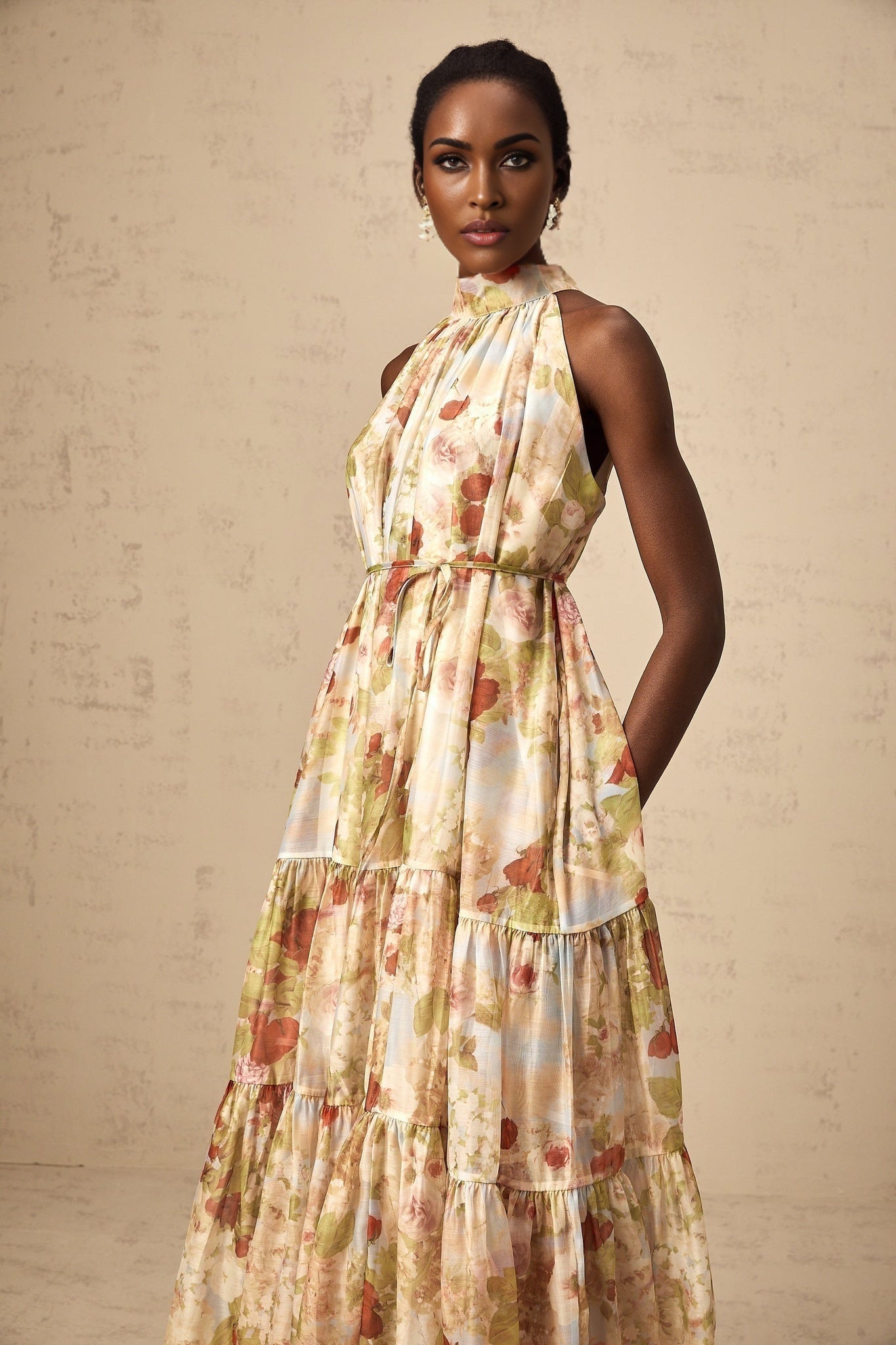 A sleeveless midi dress with a floral print pattern in neutral colors