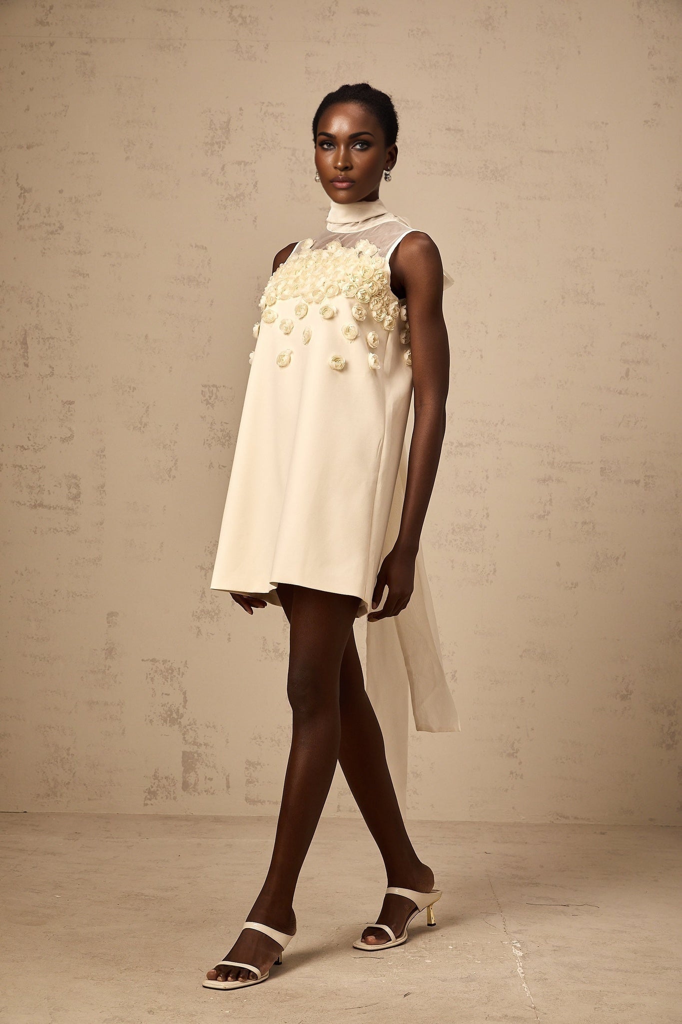 A sleeveless mini dress with faux flower decorations in a Claire style
