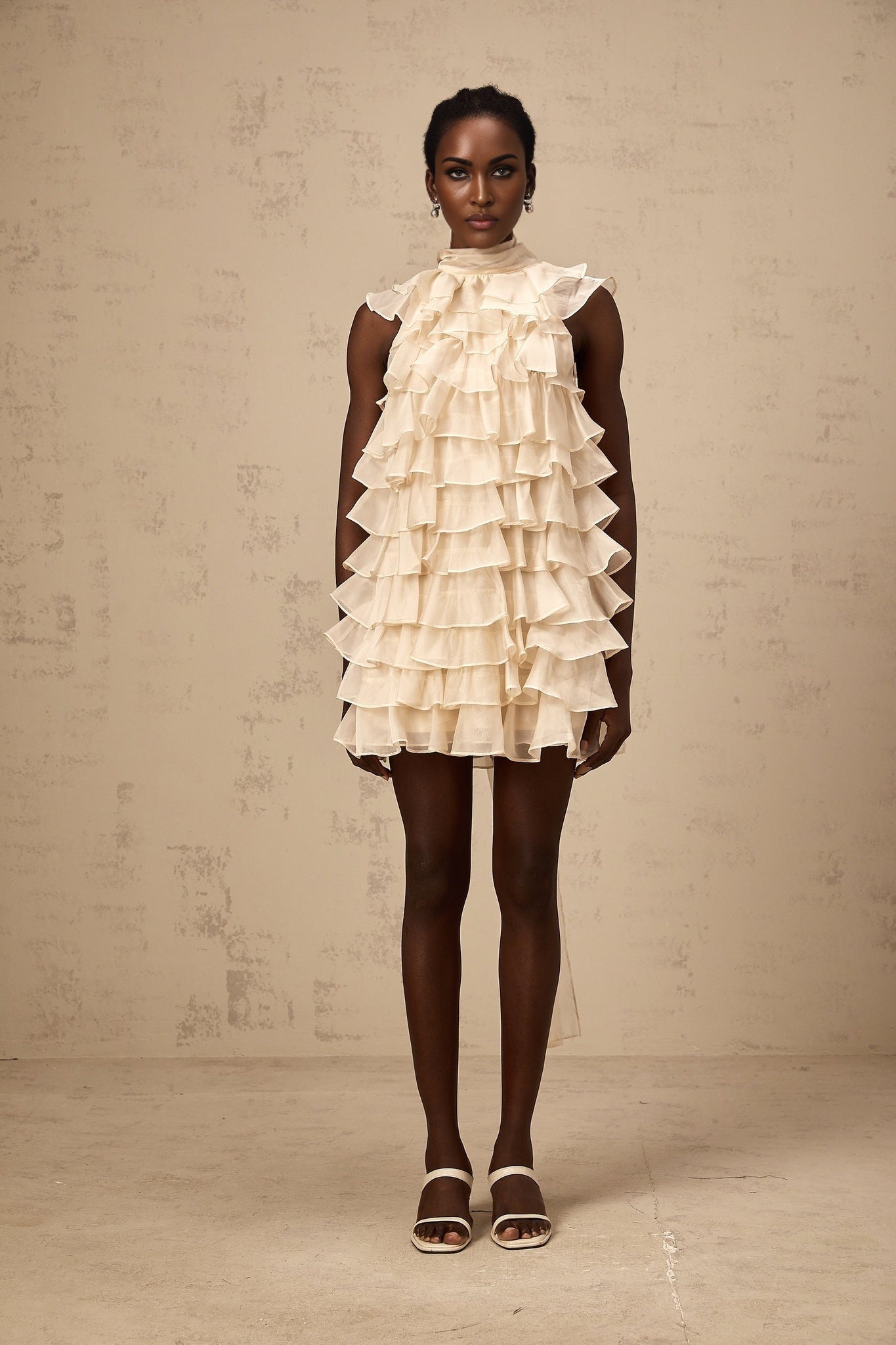 A sleeveless mini dress with tiered flounce details called Jessica featuring multiple layers of ruffles on a short skirt