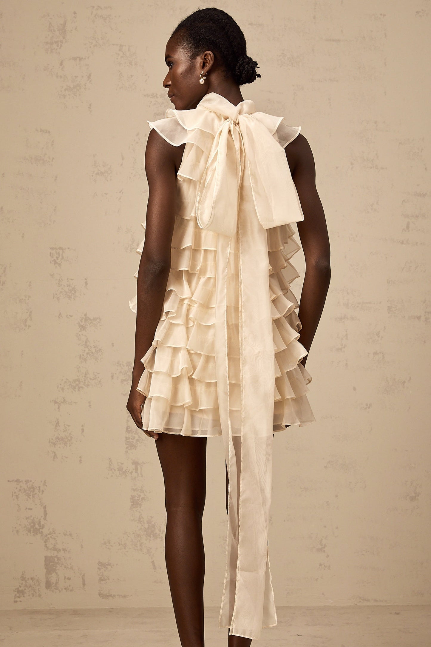A sleeveless mini dress with tiered flounce details named Jessica featuring multiple layered ruffles on a short skirt