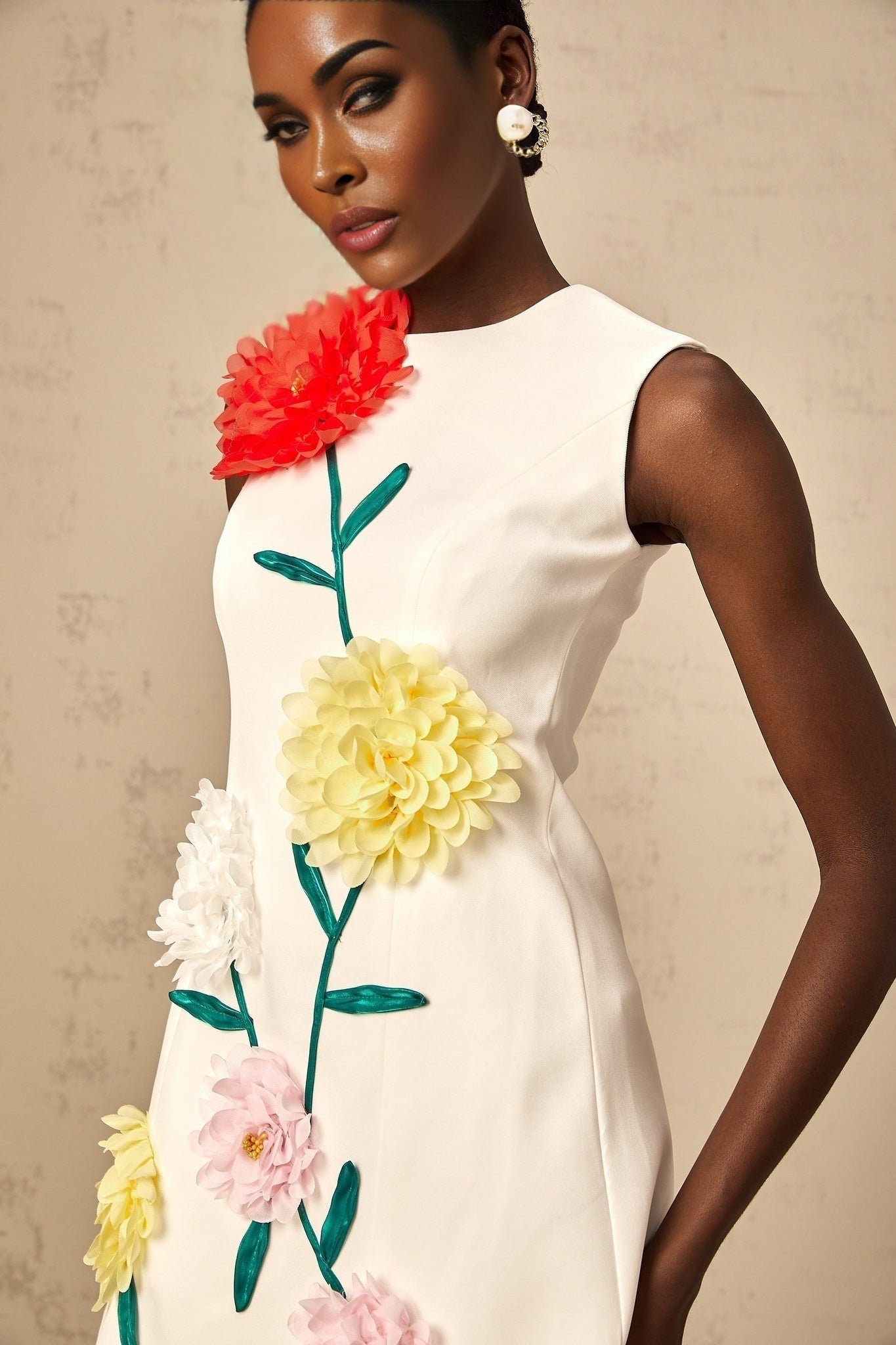 A sleeveless white mini dress with 3D petal details on the bodice featuring a floral inspired texture and a short hemline