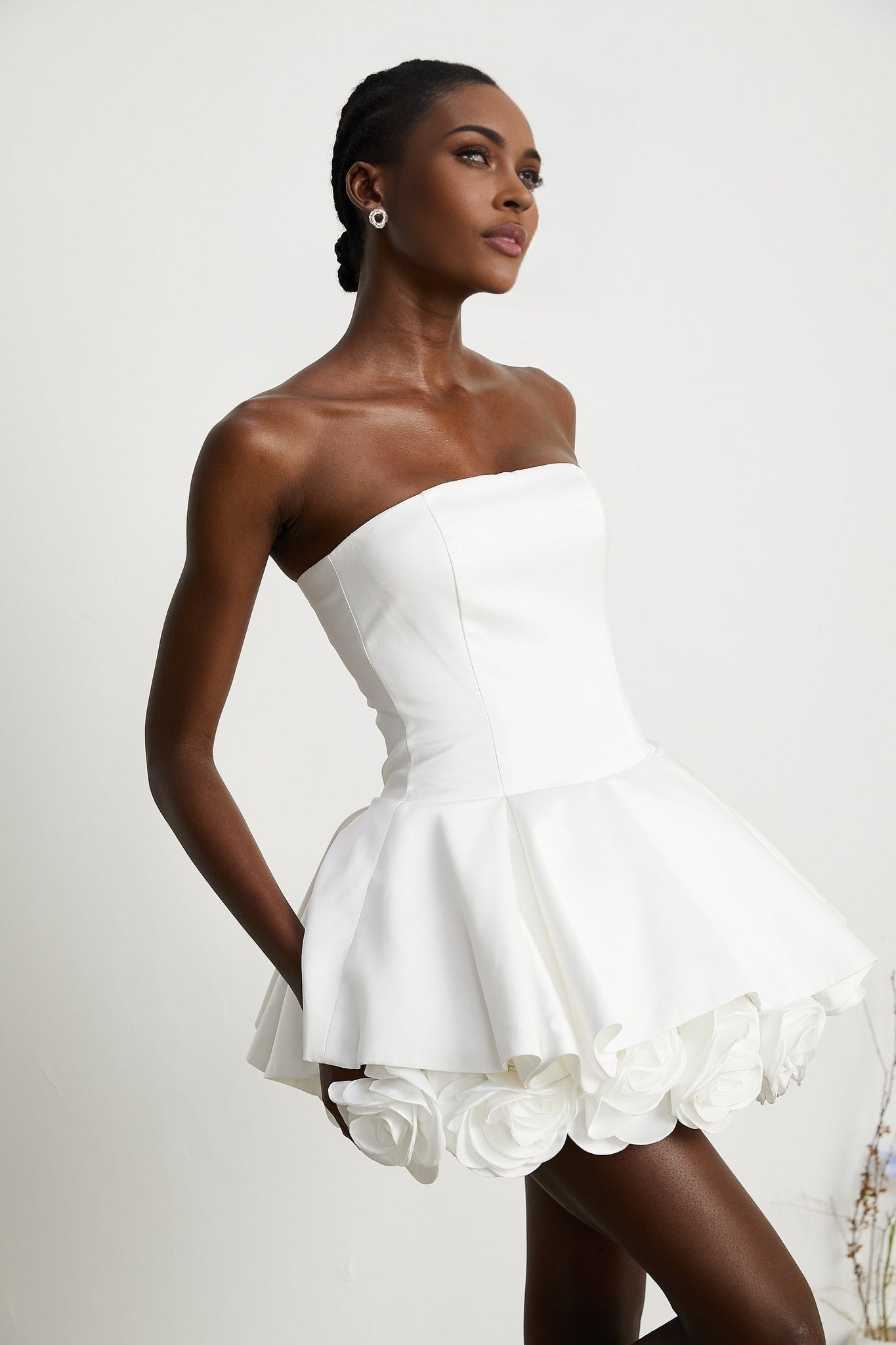 A strapless white mini dress with a corsetstyle bodice adorned with flower petals forming a floral pattern