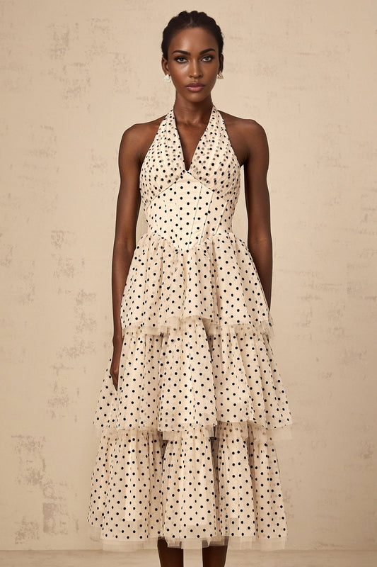A tiered midi dress in ivory color with polka dot pattern featuring multiple layers and a flowing silhouette