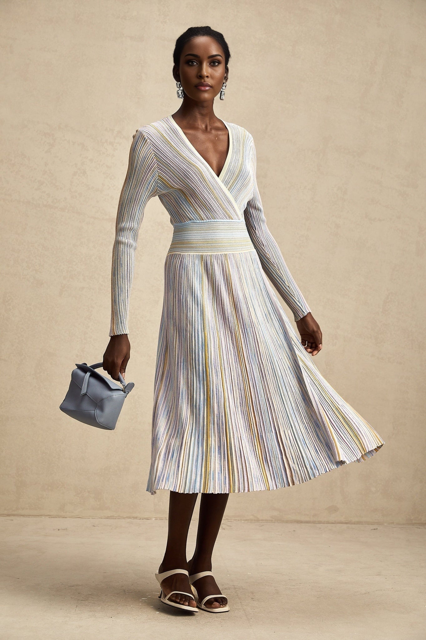 A vertical striped knitted midi dress in a fitted style featuring alternating light and dark stripes running from top to bottom named Amelie