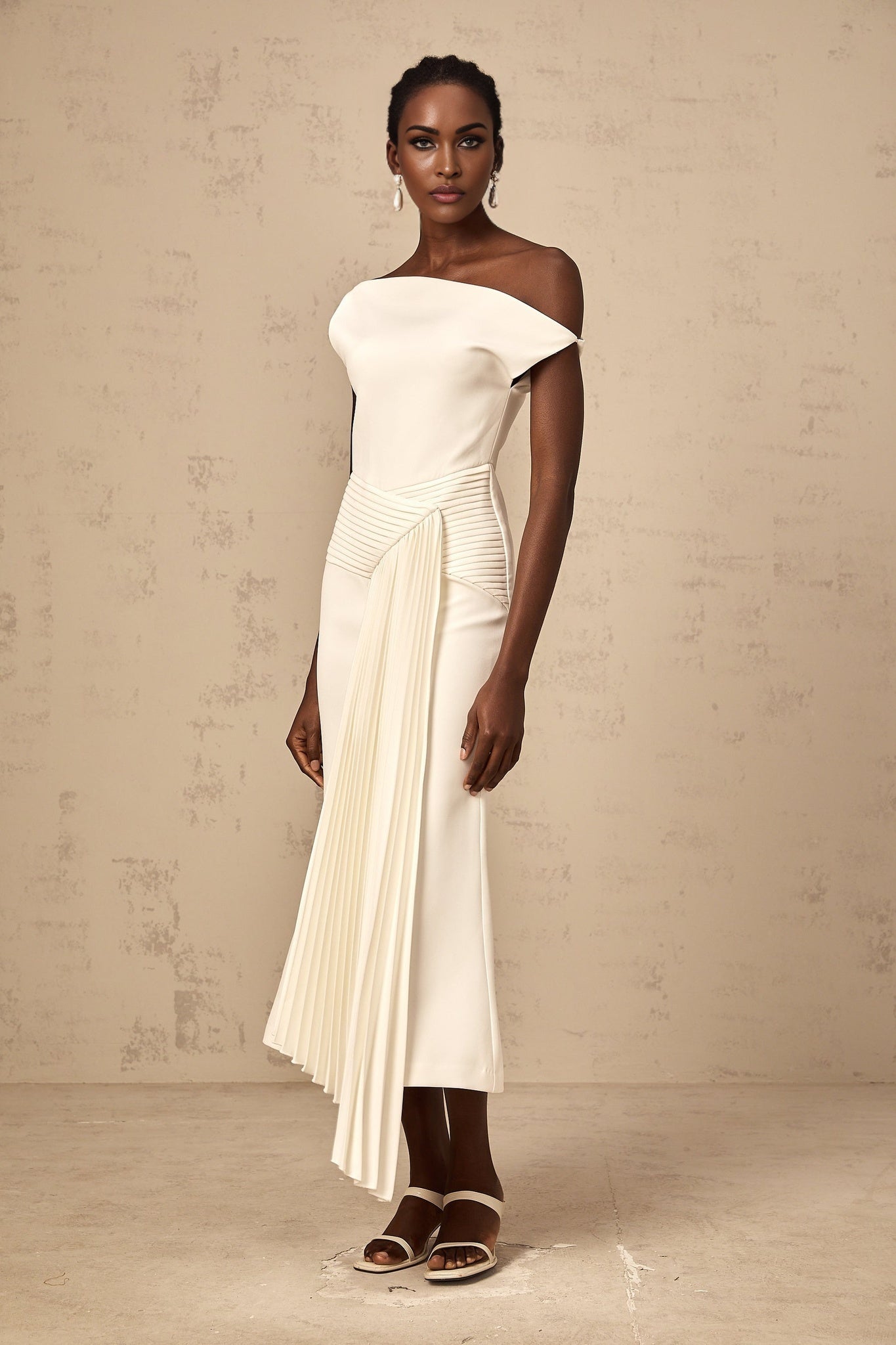 A white asymmetric draped midi dress with the name Laurine on a mannequin or model showing the draping and length of the garment