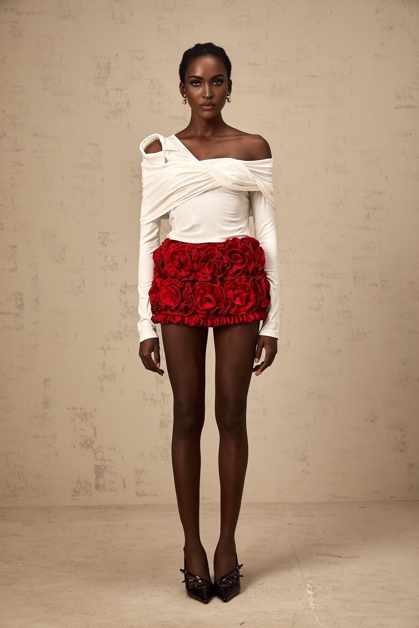 A white asymmetric top with twisted jersey fabric featuring a unique neckline and draping design