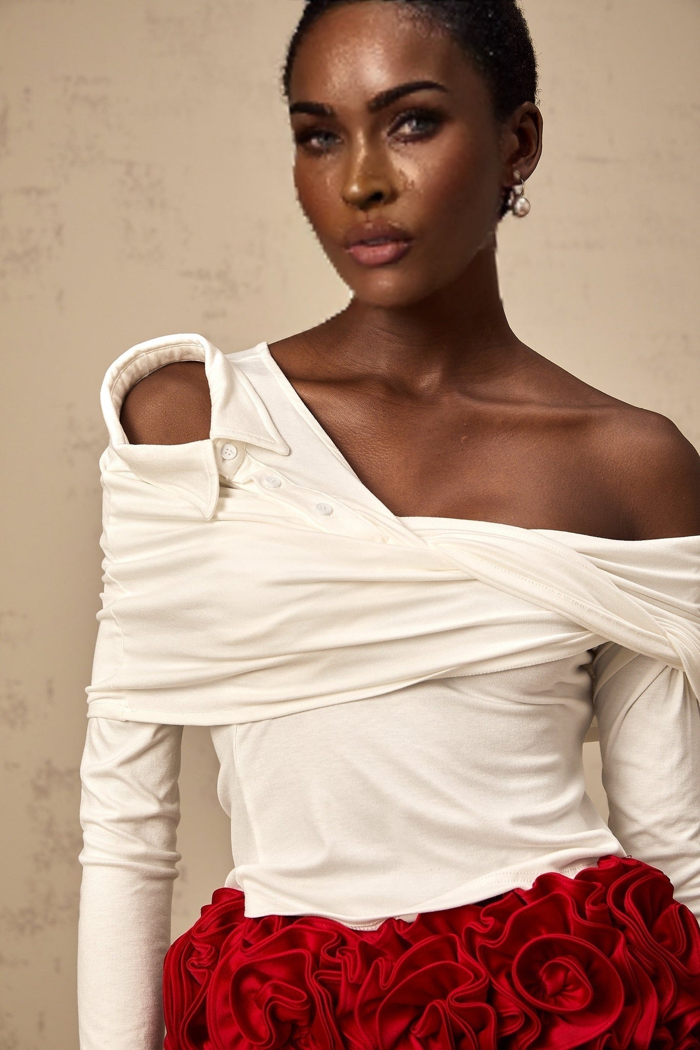 A white asymmetric top with twisted jersey fabric featuring a unique neckline and irregular hemline