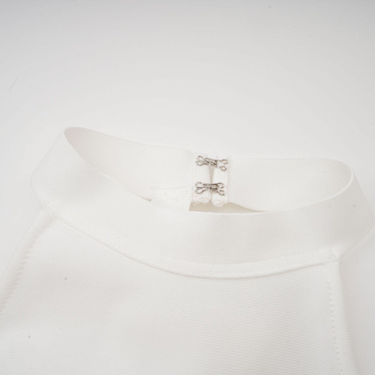 A white bandage dress with an oversized bow detail featuring a fitted silhouette and Capucine style