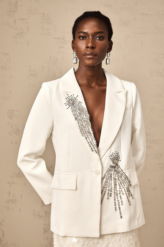 A white blazer adorned with crystal embellishments featuring a tailored fit and elegant design