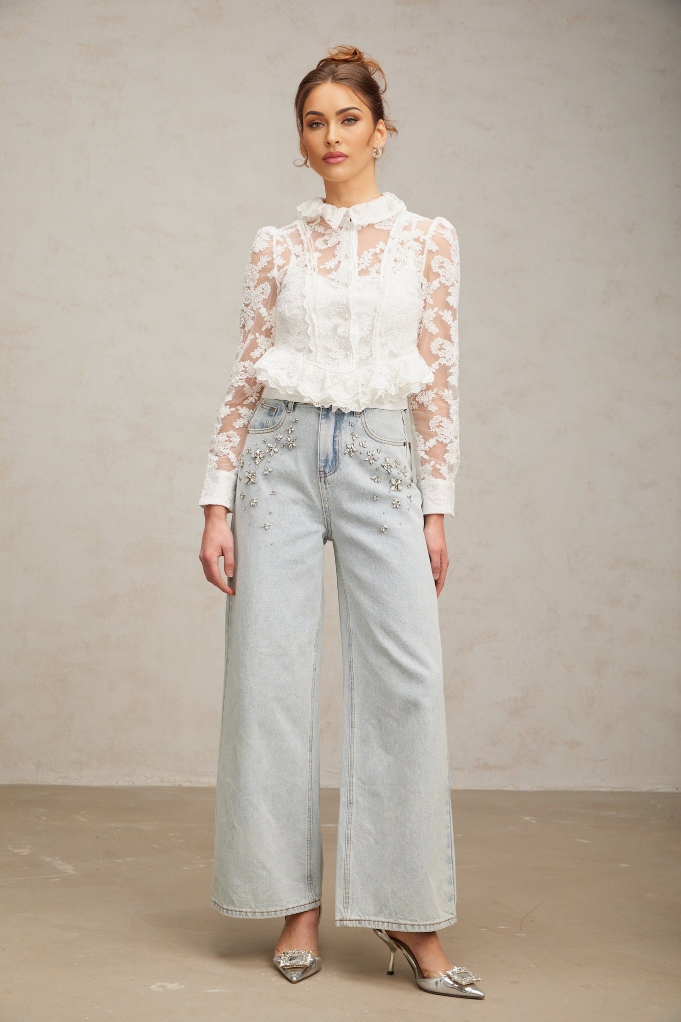 A white blouse with delicate floral embroidery and lace detailing named Karine