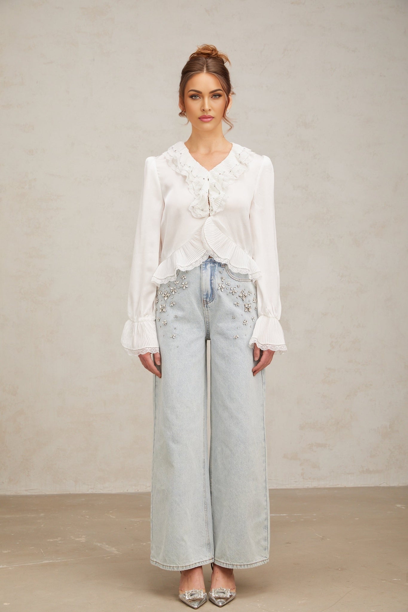 A white buttonup shirt with lace trim and ruffled details named Aimee
