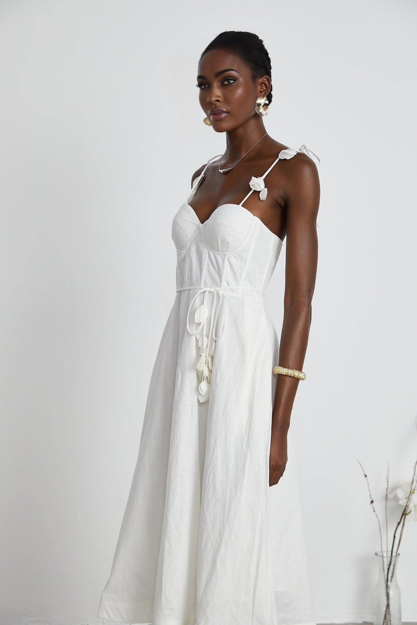 A white corsetstyle midi dress with a fitted bodice and flared skirt featuring a sweetheart neckline and thin straps