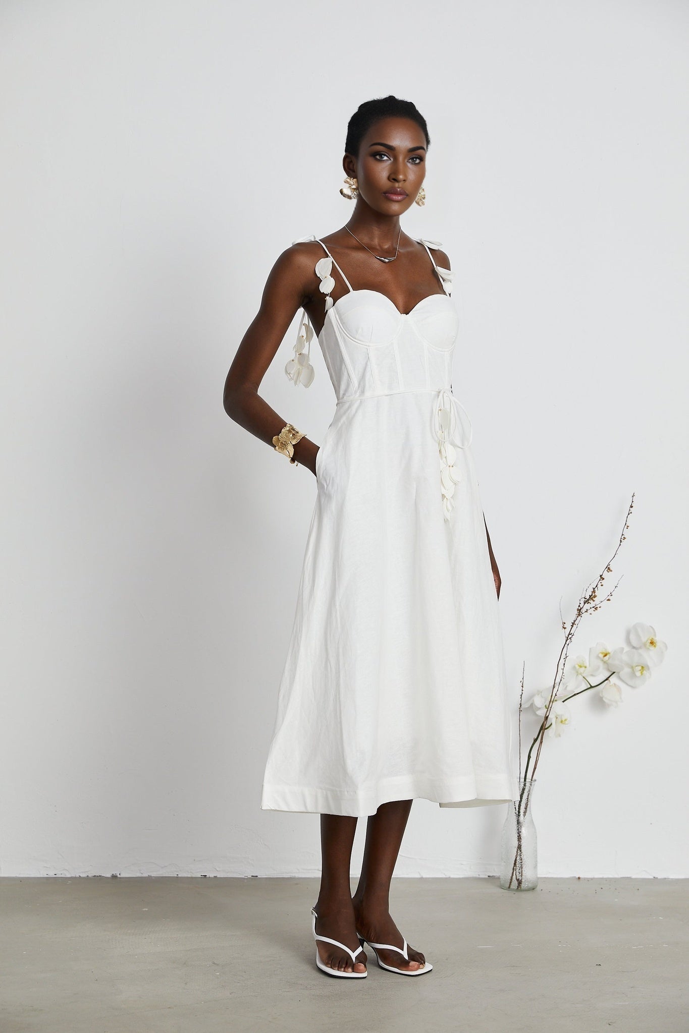 A white corsetstyle midi dress with a fitted bodice and flared skirt named Helene