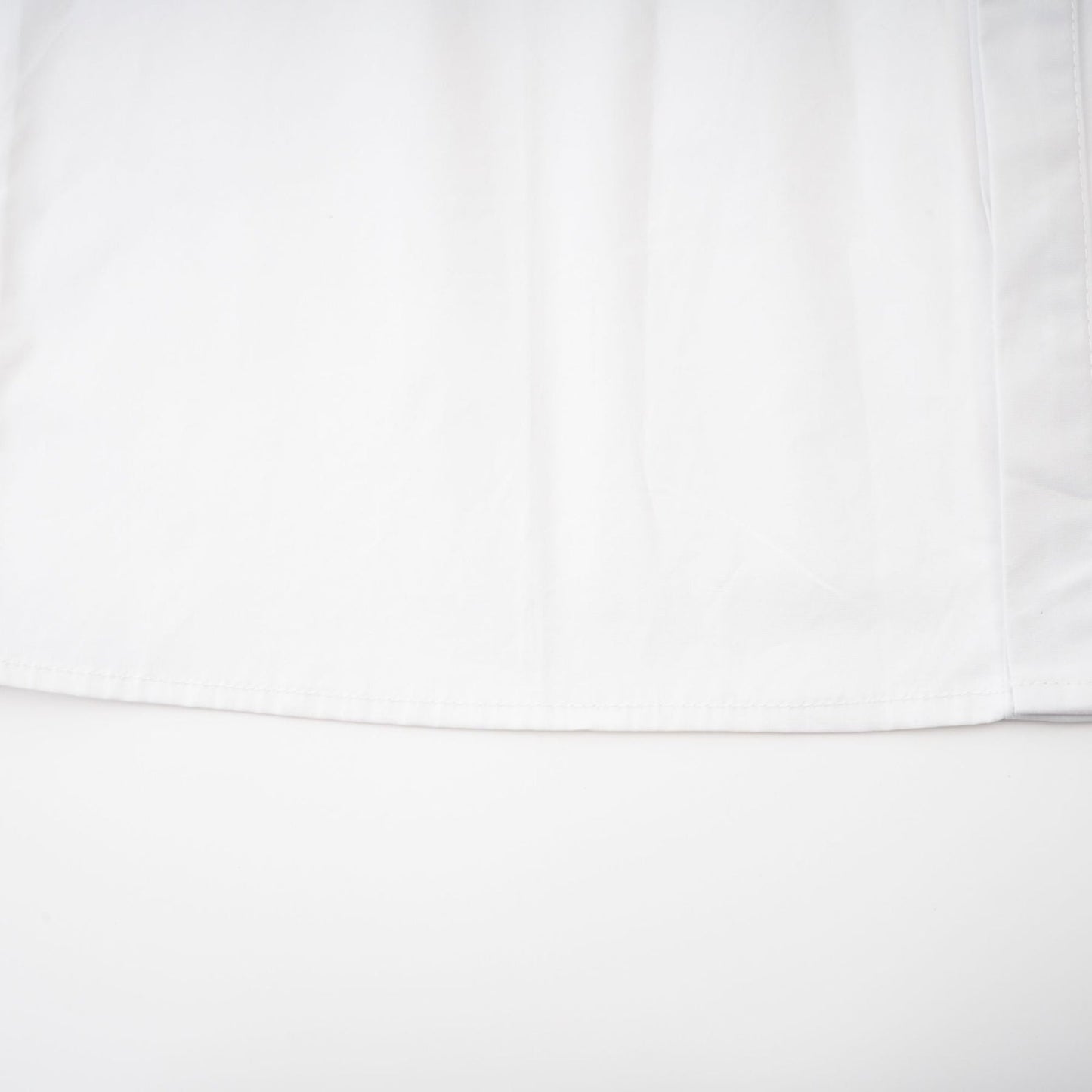 A white cotton buttonup shirt with long sleeves and a tie front detail at the waist named Solene