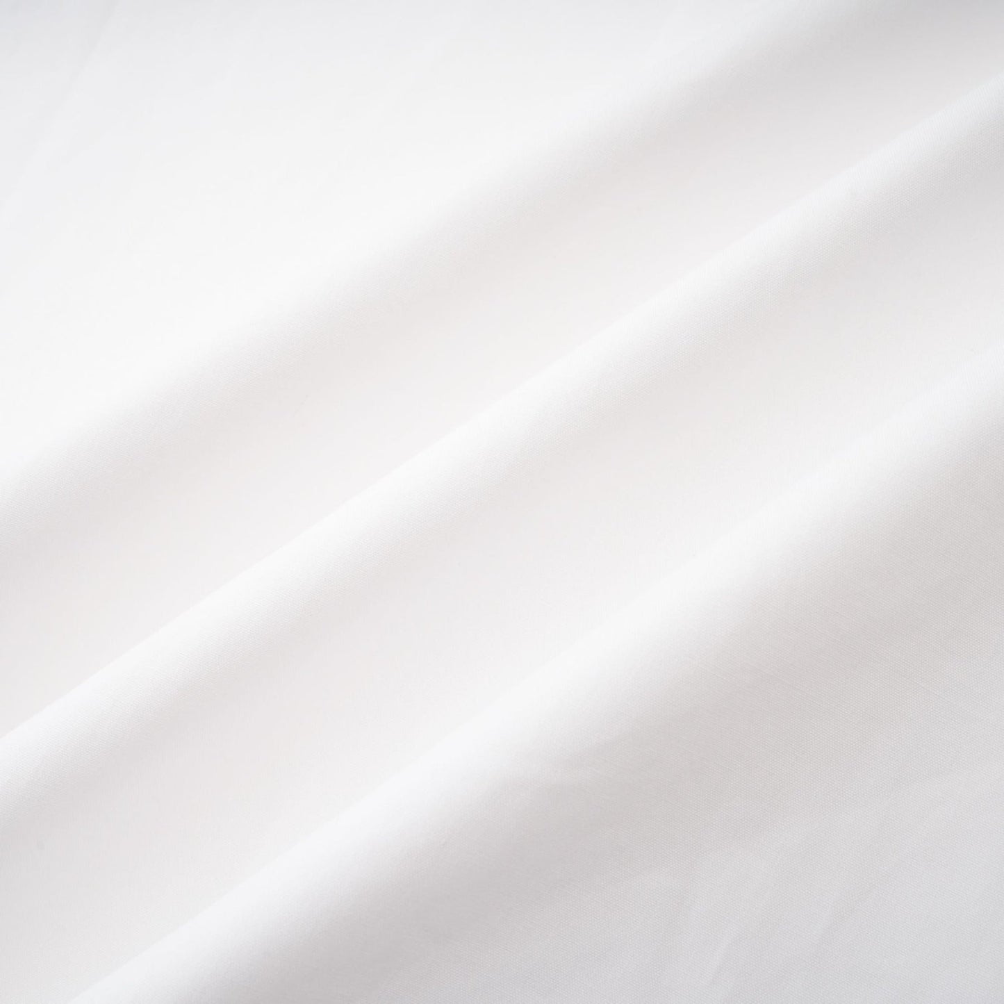 A white cotton buttonup shirt with long sleeves and a tie front detail named Solene