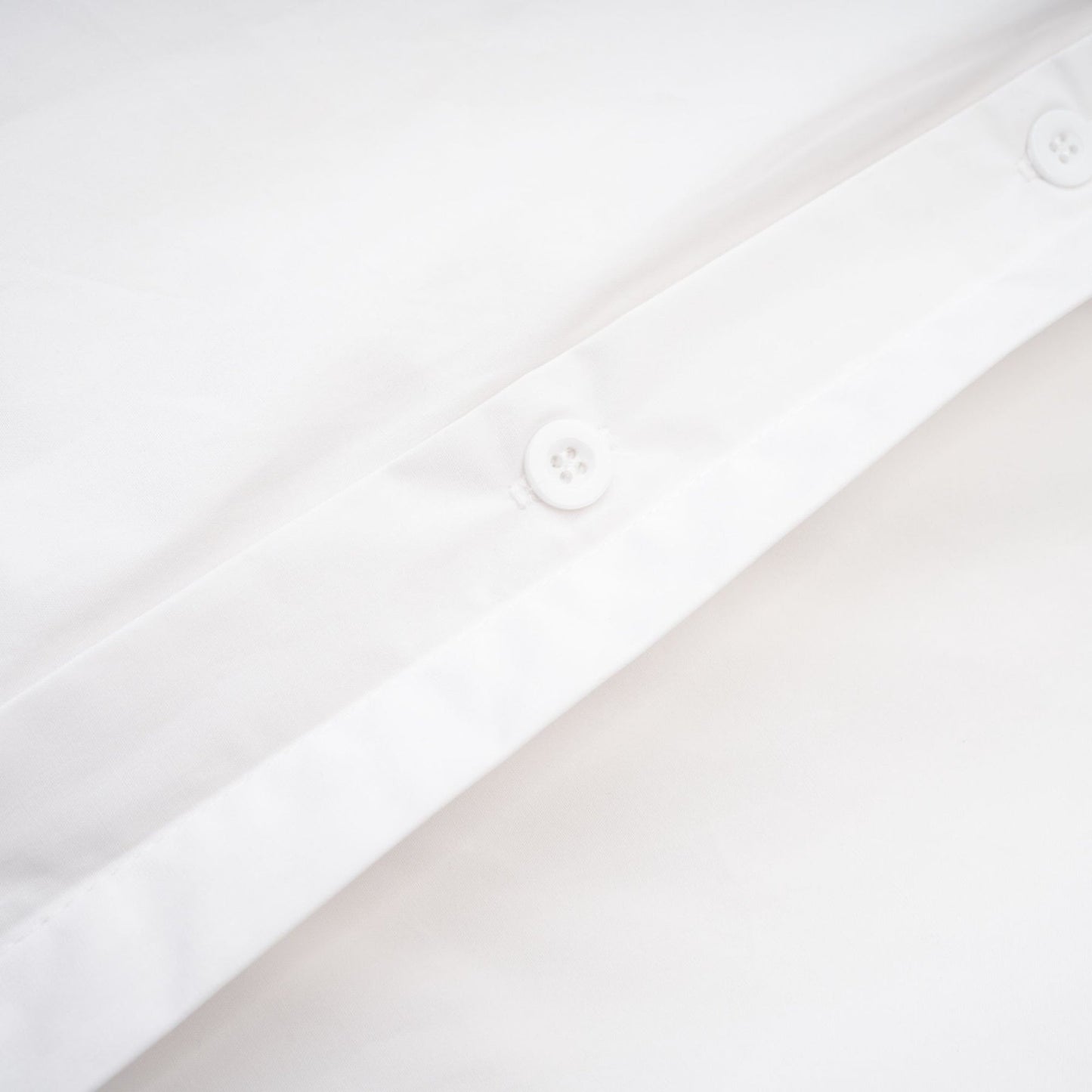 A white cotton buttonup shirt with long sleeves and a tie front detail named Solene