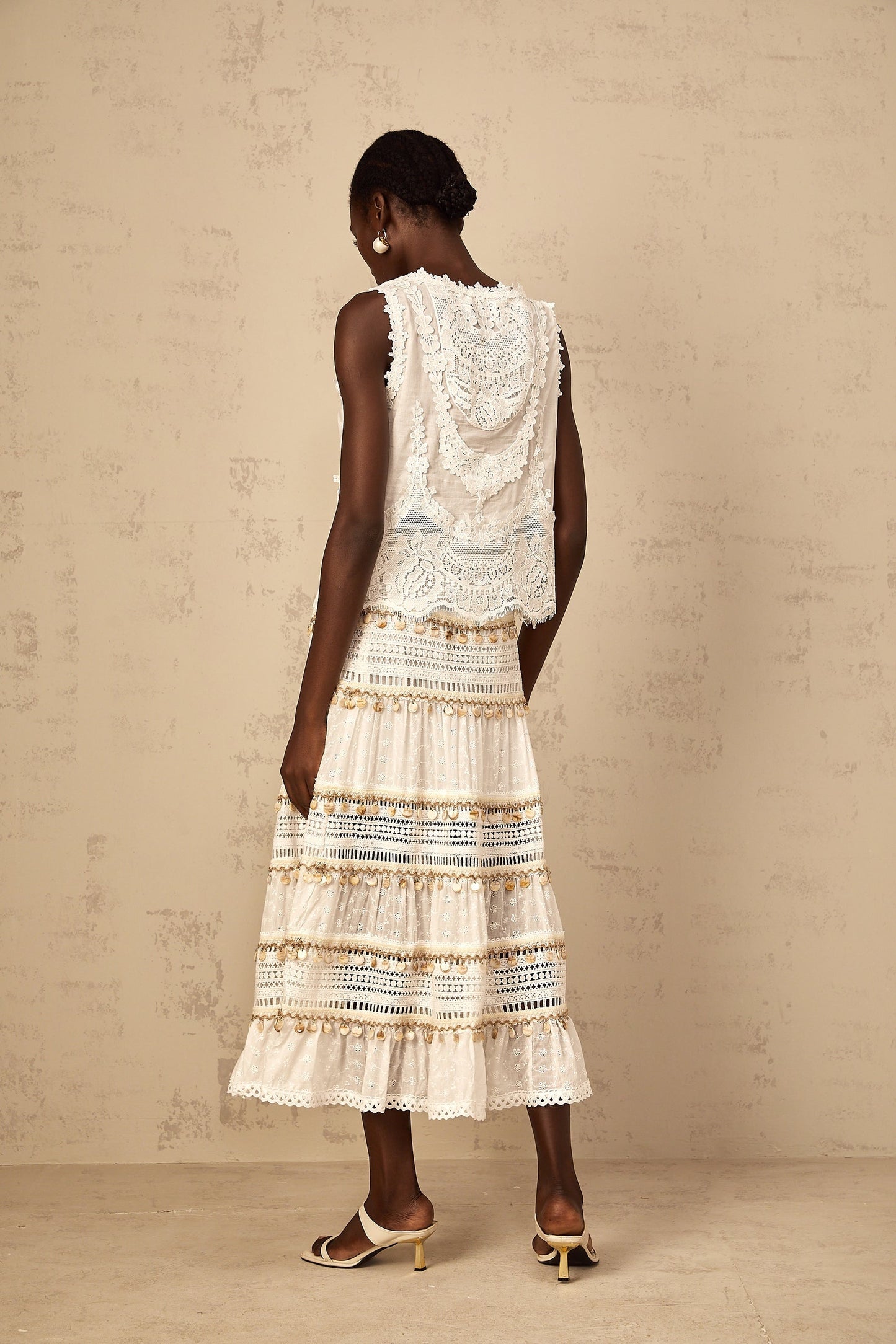A white cropped tank top with delicate floral embroidery detail on the front