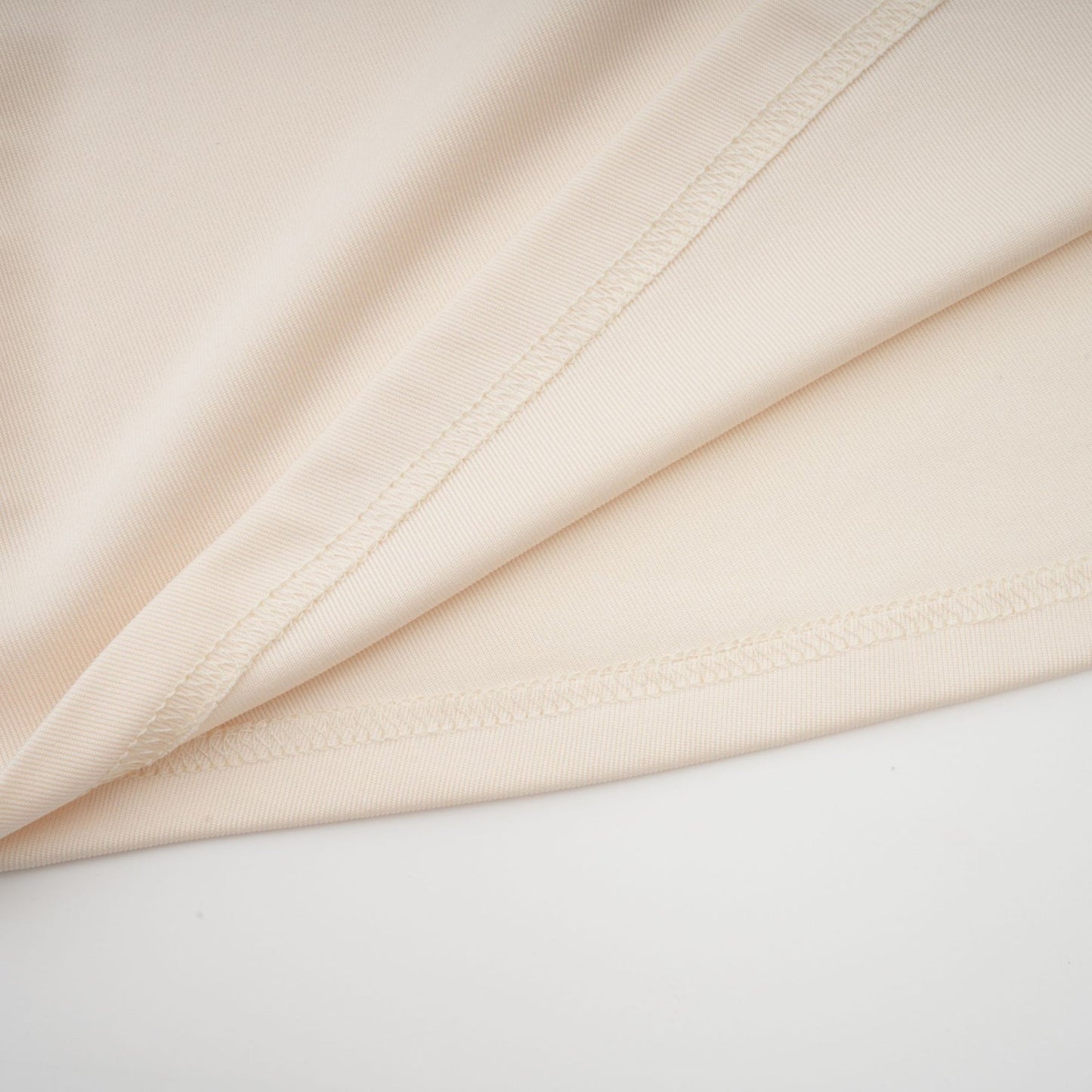 A white floorlength maxi dress with a deep V neckline and draped fabric details worn by a model