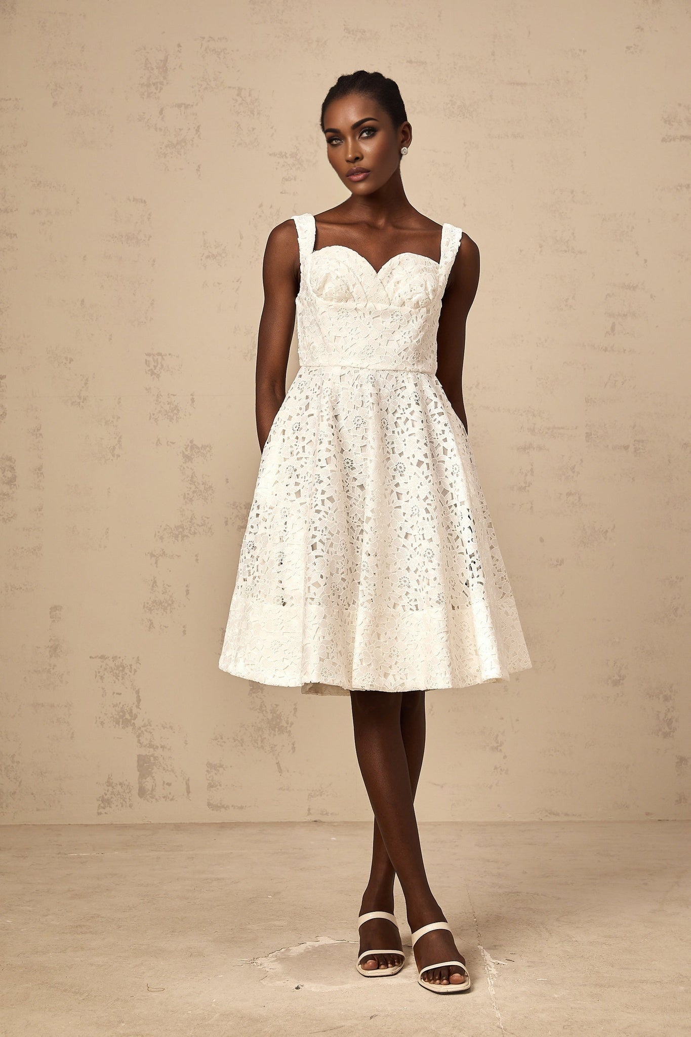 A white floral lace midi dress with delicate patterns and intricate details named Nicolette