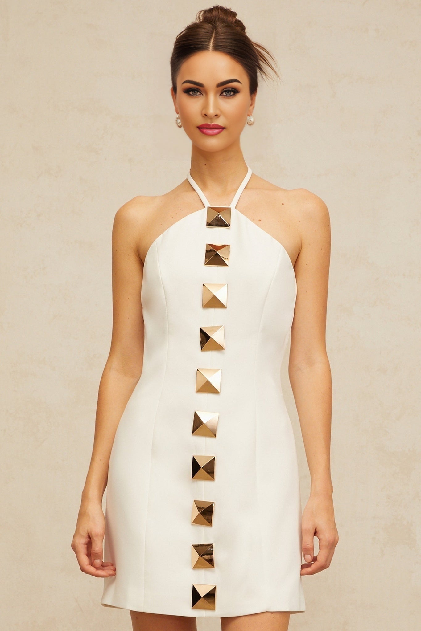 A white halterneck mini dress with an Aline silhouette named Annabelle worn by a model against a plain background