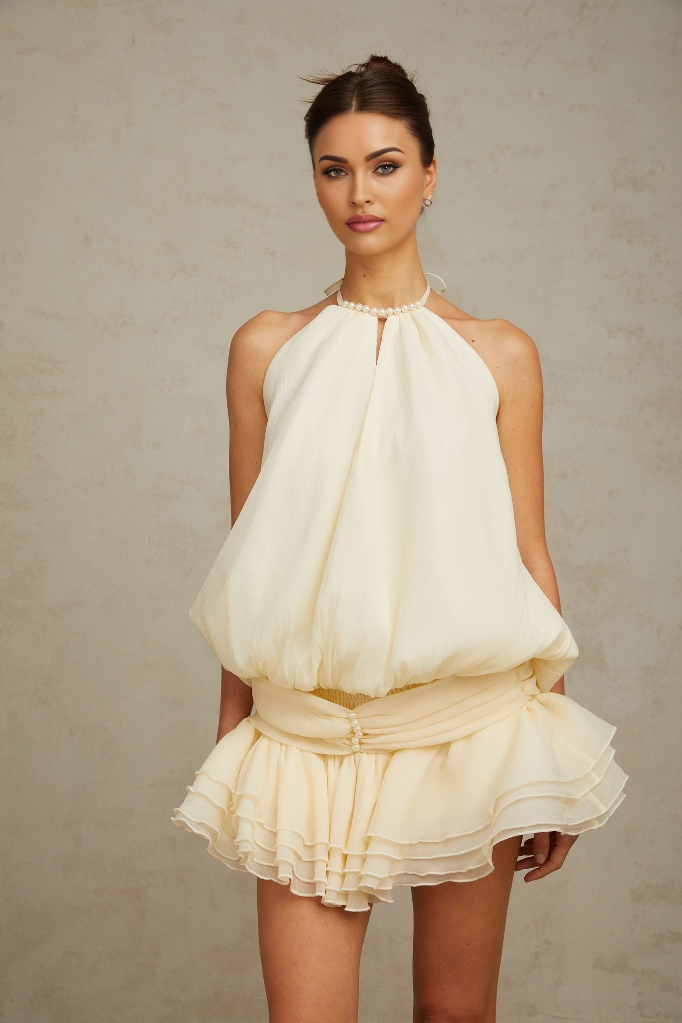 A white halterneck mini dress with faux pearl embellishments named Berenice