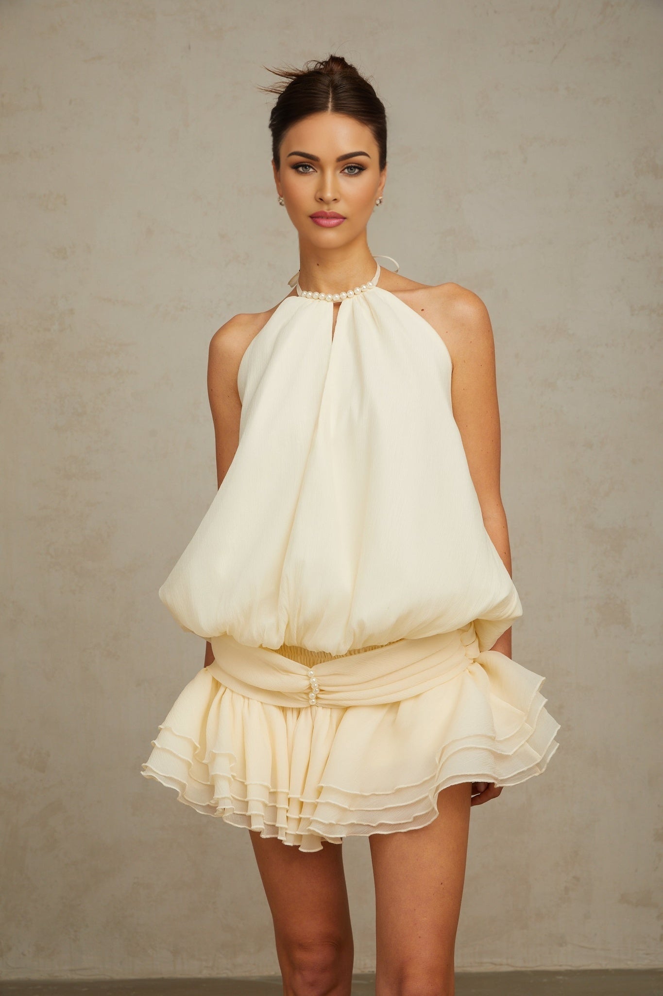 A white halterneck mini dress with faux pearl embellishments named Berenice