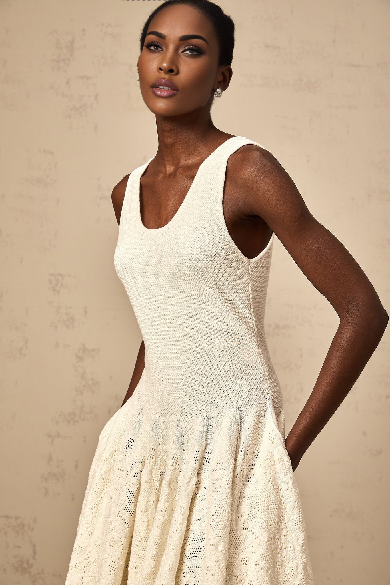 A white jacquard knit mini dress with a formfitting silhouette and textured pattern