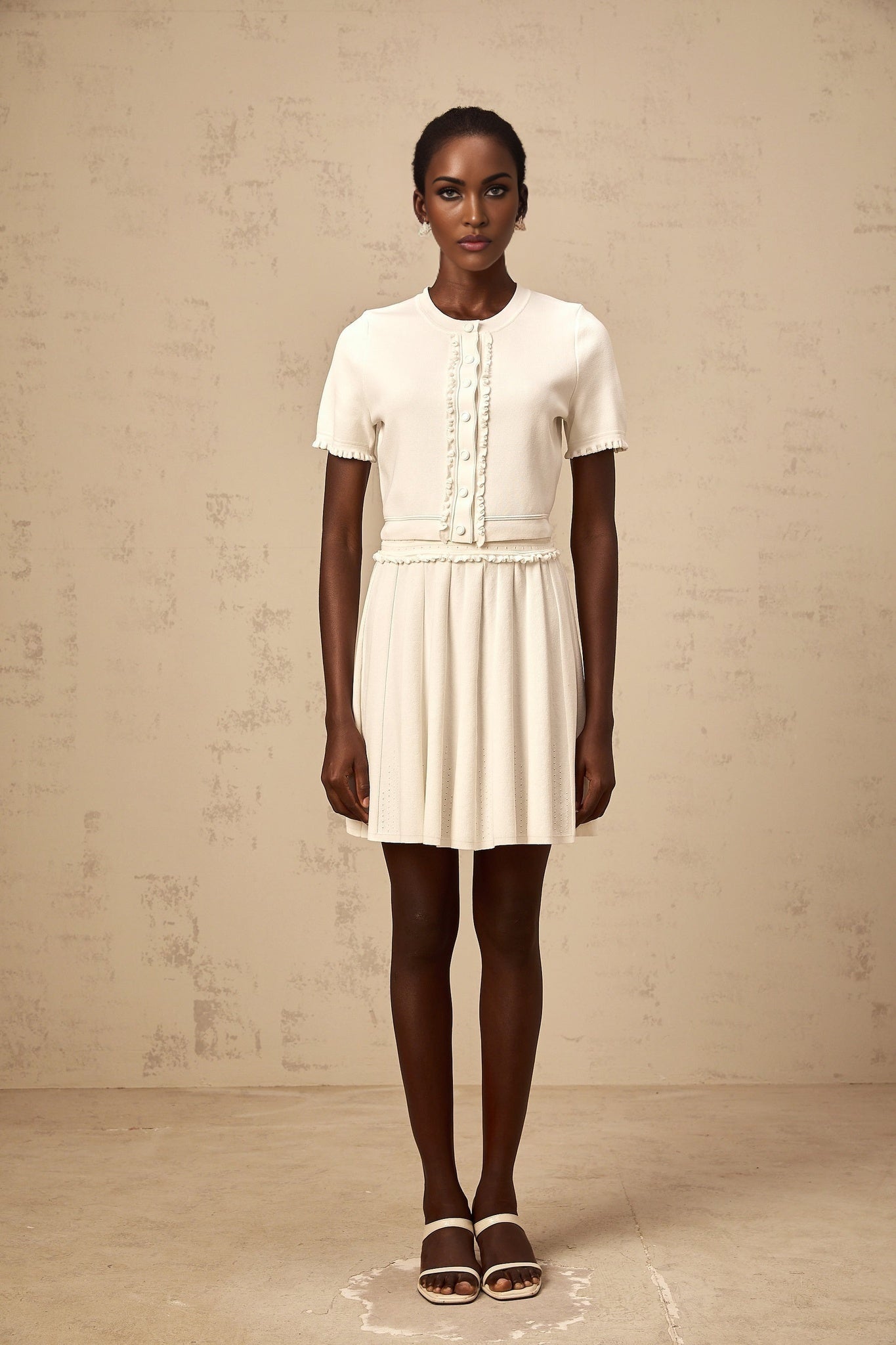 A white knit matching set consisting of a ruffled trim top and skirt inspired by Zelda style