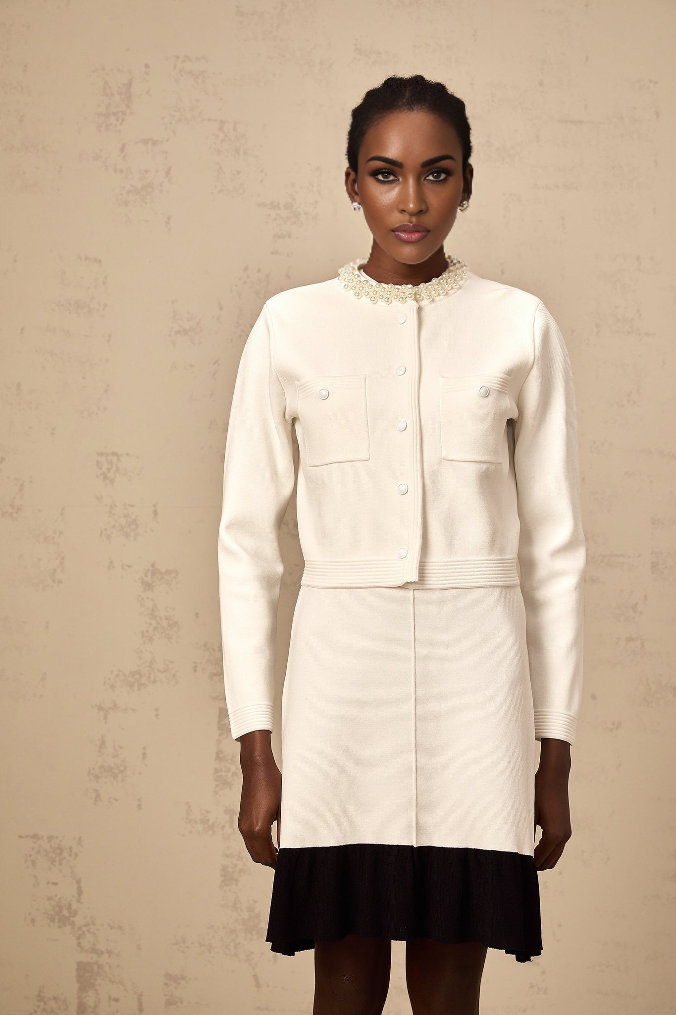 A white knitted cardigan adorned with faux pearl embellishments called Coralie