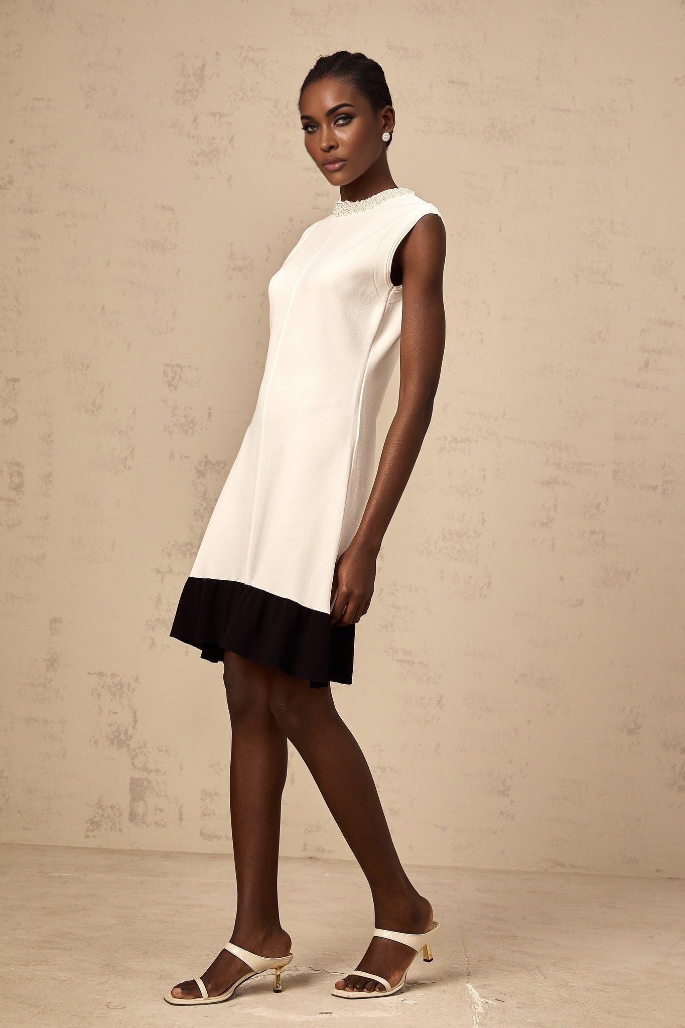 A white knitted cardigan adorned with faux pearl embellishments named Coralie