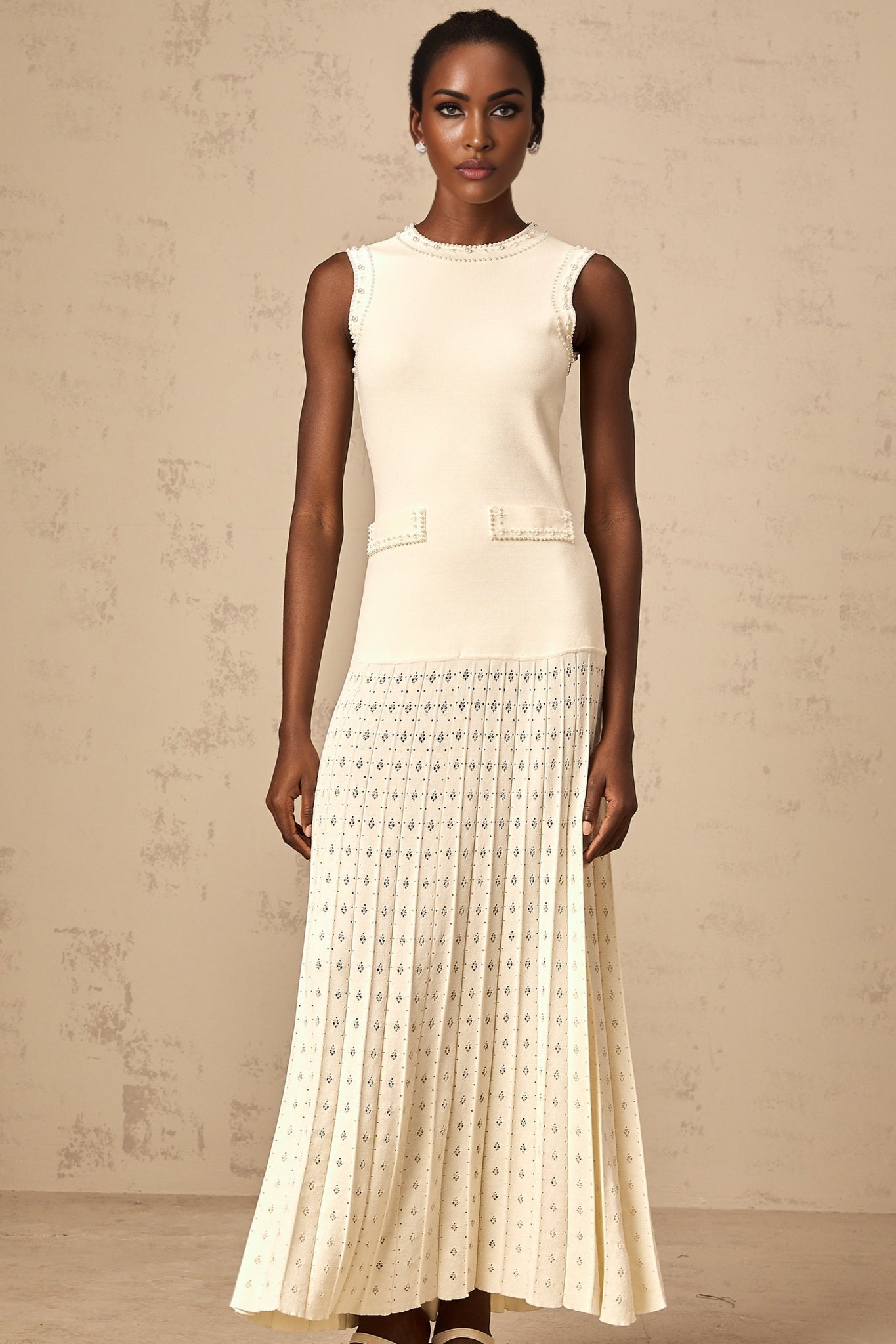 A white knitted maxi dress with faux pearl embellishments by Donatienne