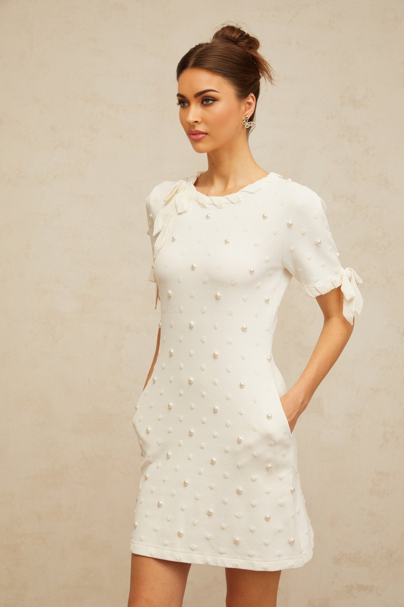 A white knitted mini dress with a polka dot pattern and heart design featuring the Prunelle brand