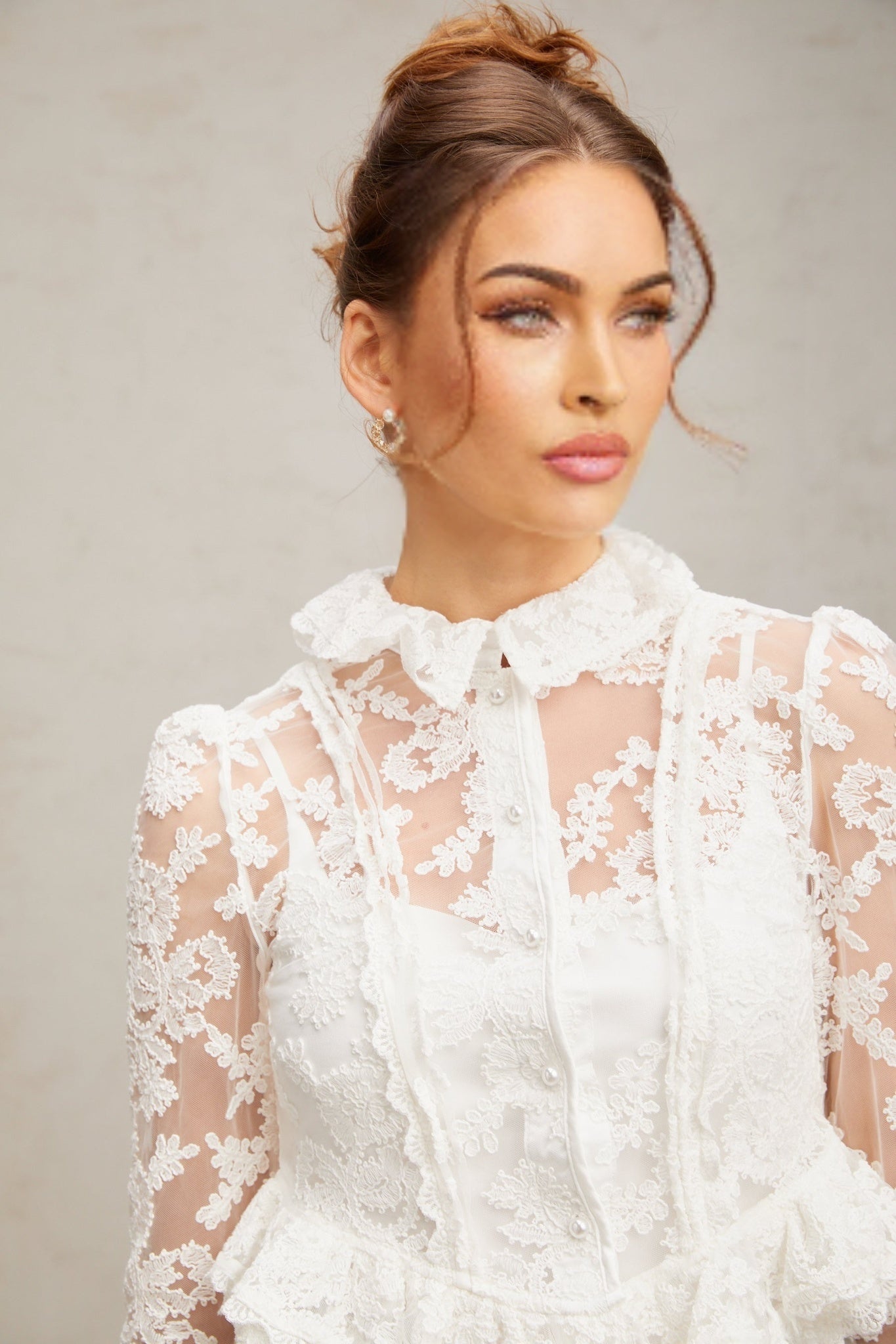 A white lace blouse with floral embroidery patterns featuring a delicate feminine design named Karine