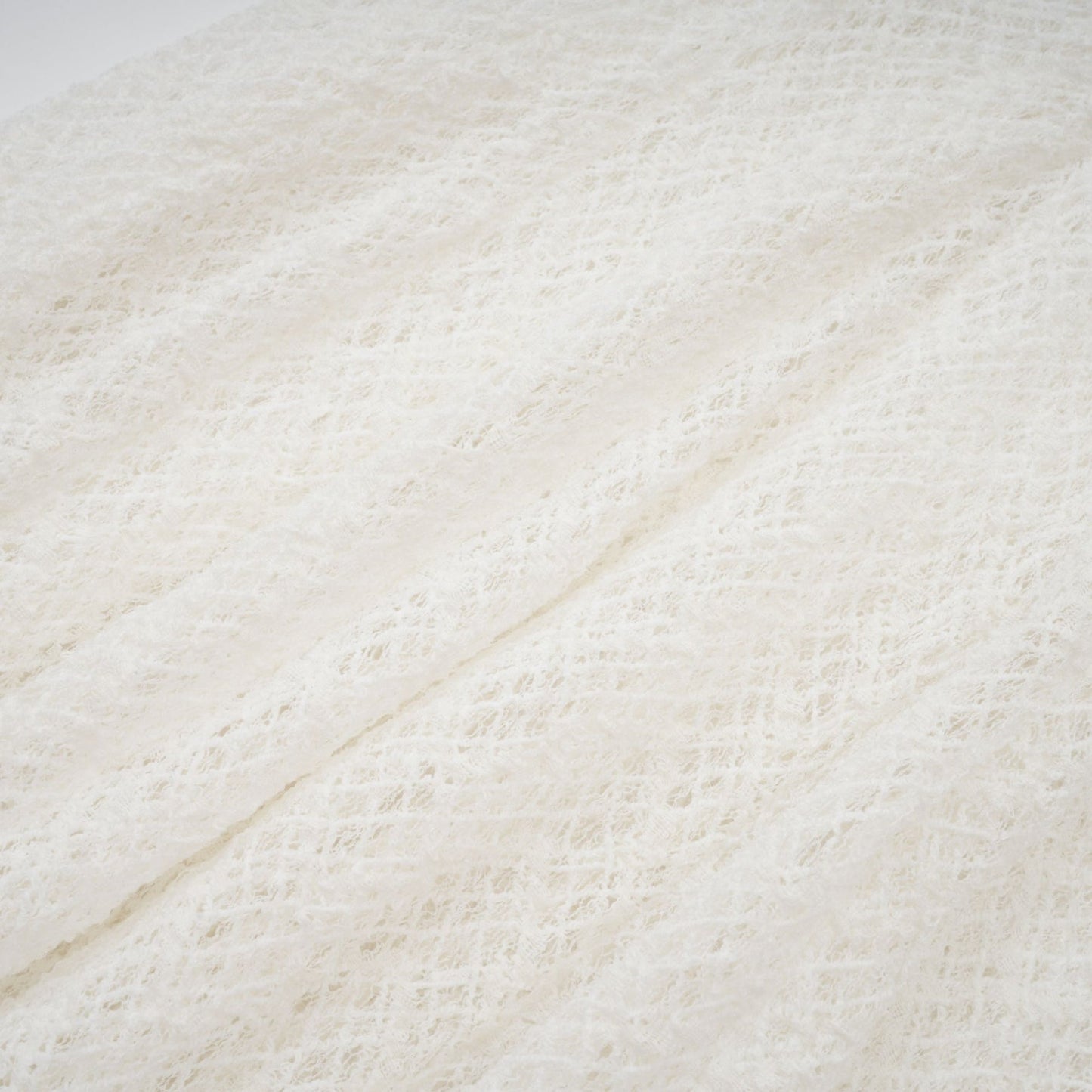 A white lace maxi dress with a wavy pattern covering the entire garment featuring a long flowing skirt and intricate lace detailing throughout