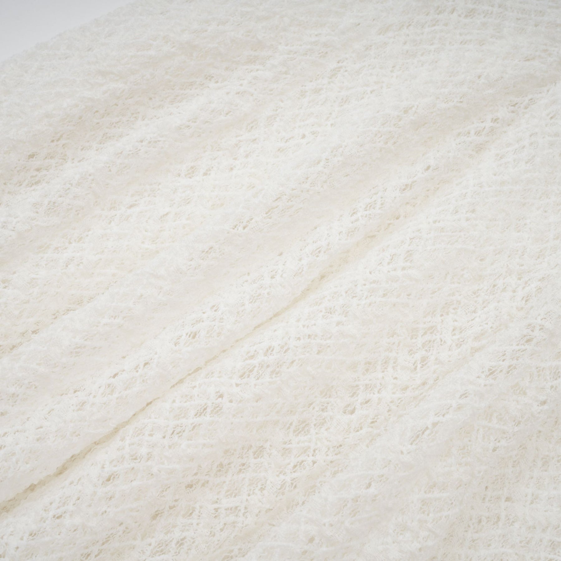 A white lace maxi dress with a wavy pattern covering the entire garment featuring a long flowing skirt and intricate lace detailing throughout