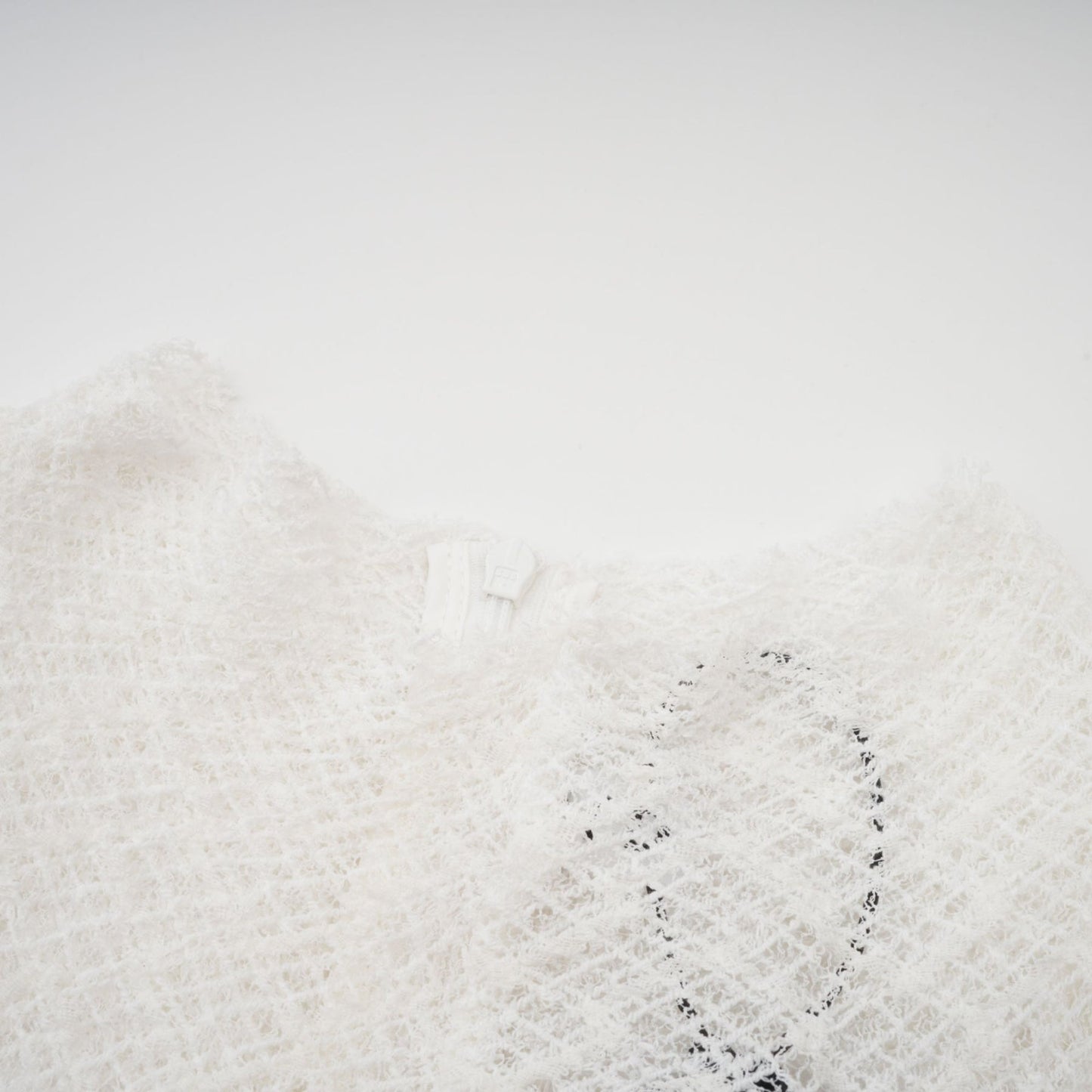 A white lace maxi dress with a wavy pattern design featuring a long flowing skirt and intricate lace detailing throughout