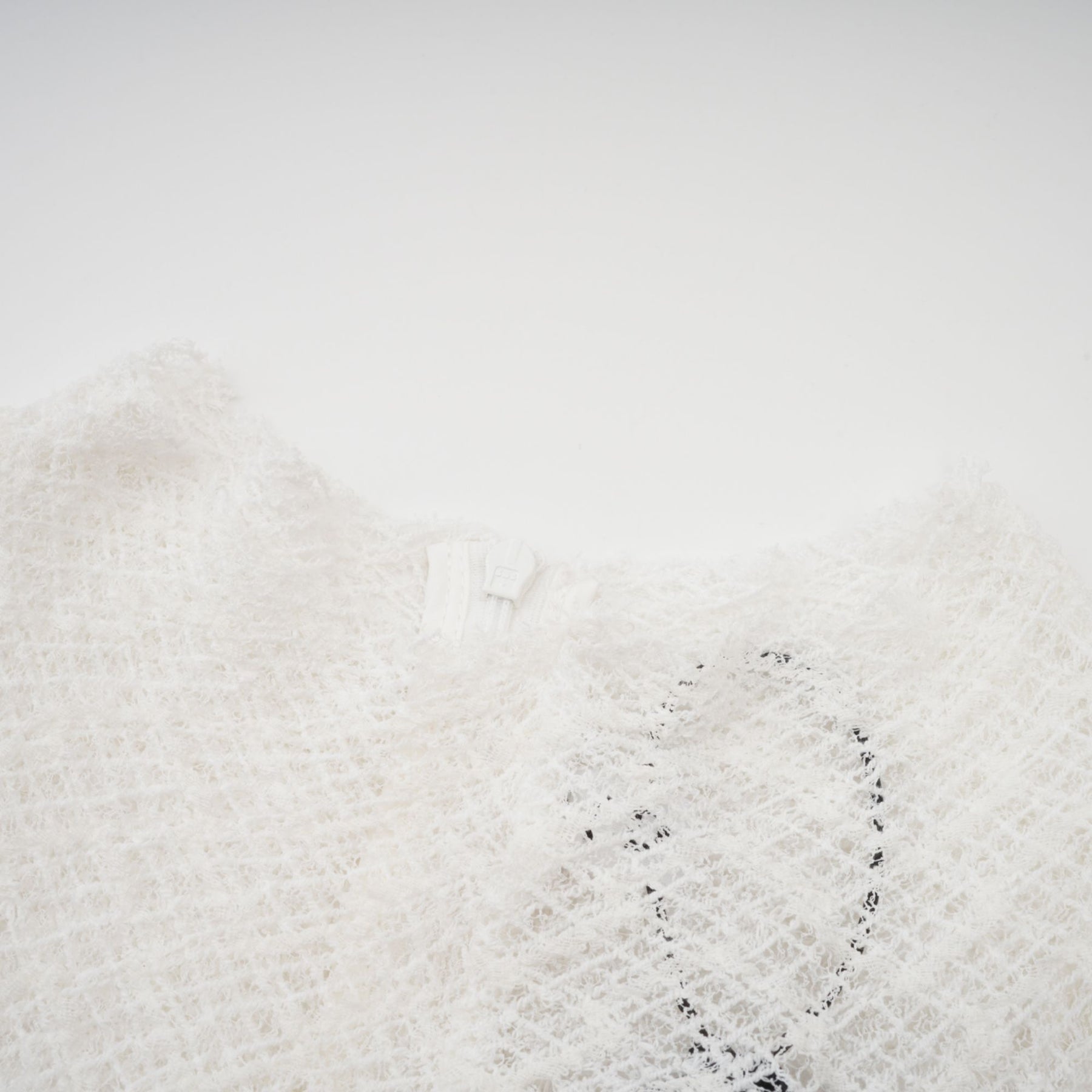 A white lace maxi dress with a wavy pattern design featuring a long flowing skirt and intricate lace detailing throughout